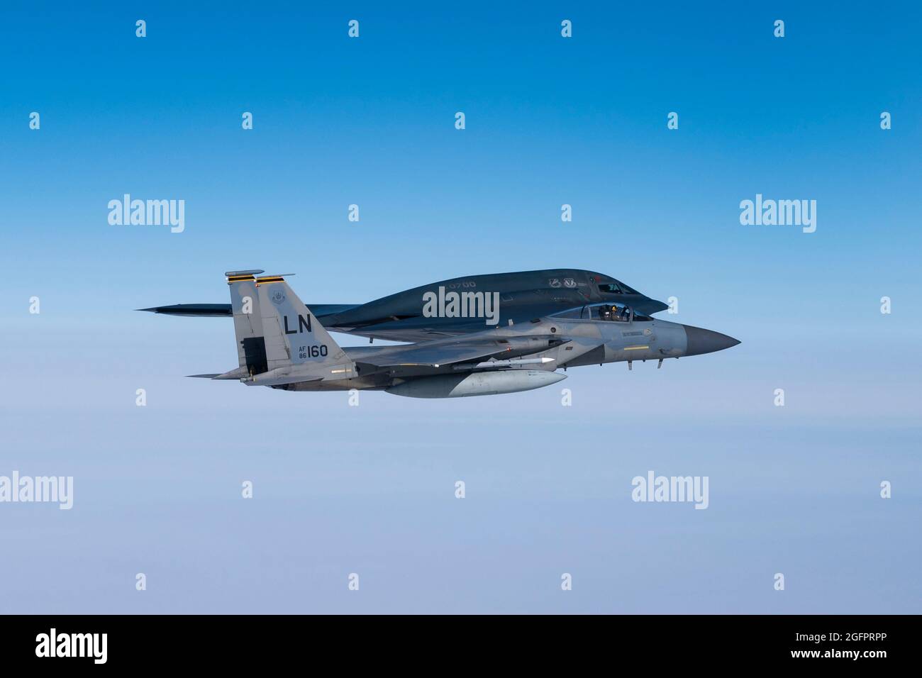Nordsee, Großbritannien. August 2021. Ein F-15C Eagle-Kampfflugzeug der US Air Force, das dem 493rd Fighter Squadron zugewiesen wurde, fliegt während eines Trainings über der Nordsee am 25. August 2021 vor der Küste Schottlands an der Seite eines B-2 Spirit Stealth-Bombers. Quelle: Planetpix/Alamy Live News Stockfoto