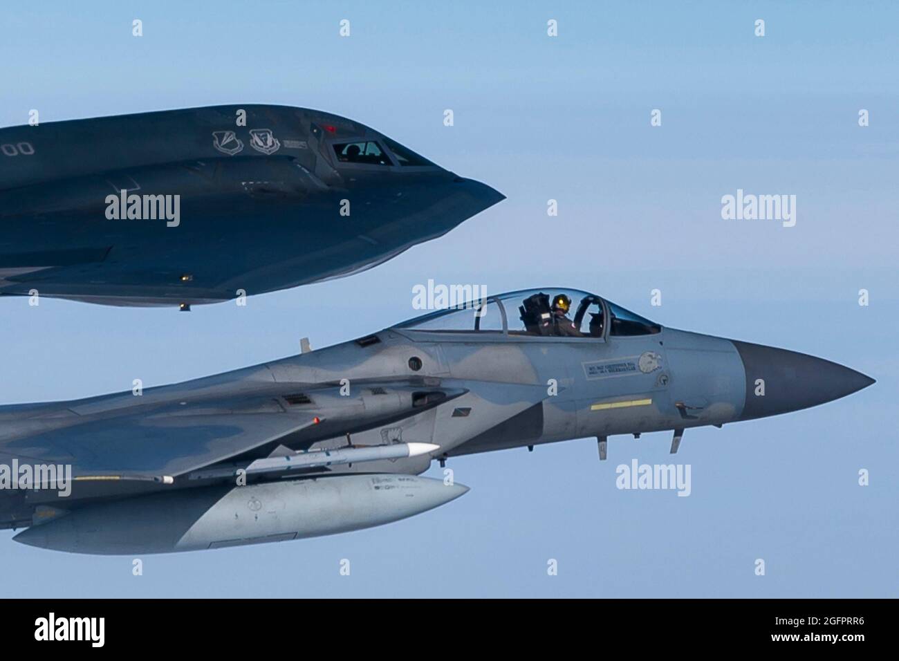 Nordsee, Großbritannien. August 2021. Ein F-15C Eagle-Kampfflugzeug der US Air Force, das dem 493rd Fighter Squadron zugewiesen wurde, fliegt während eines Trainings über der Nordsee am 25. August 2021 vor der Küste Schottlands an der Seite eines B-2 Spirit Stealth-Bombers. Quelle: Planetpix/Alamy Live News Stockfoto