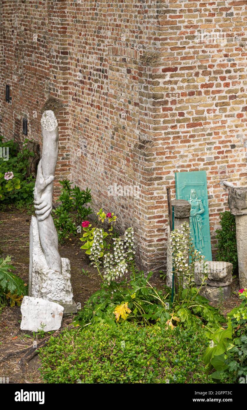 Brügge, Flandern, Belgien - 4. August 2021: Menschen helfen Menschen symbolische Statue im Kloster Rooms, mittelalterliches Godshuis, von der Gilde gesponserte Gemeinschaft housi Stockfoto