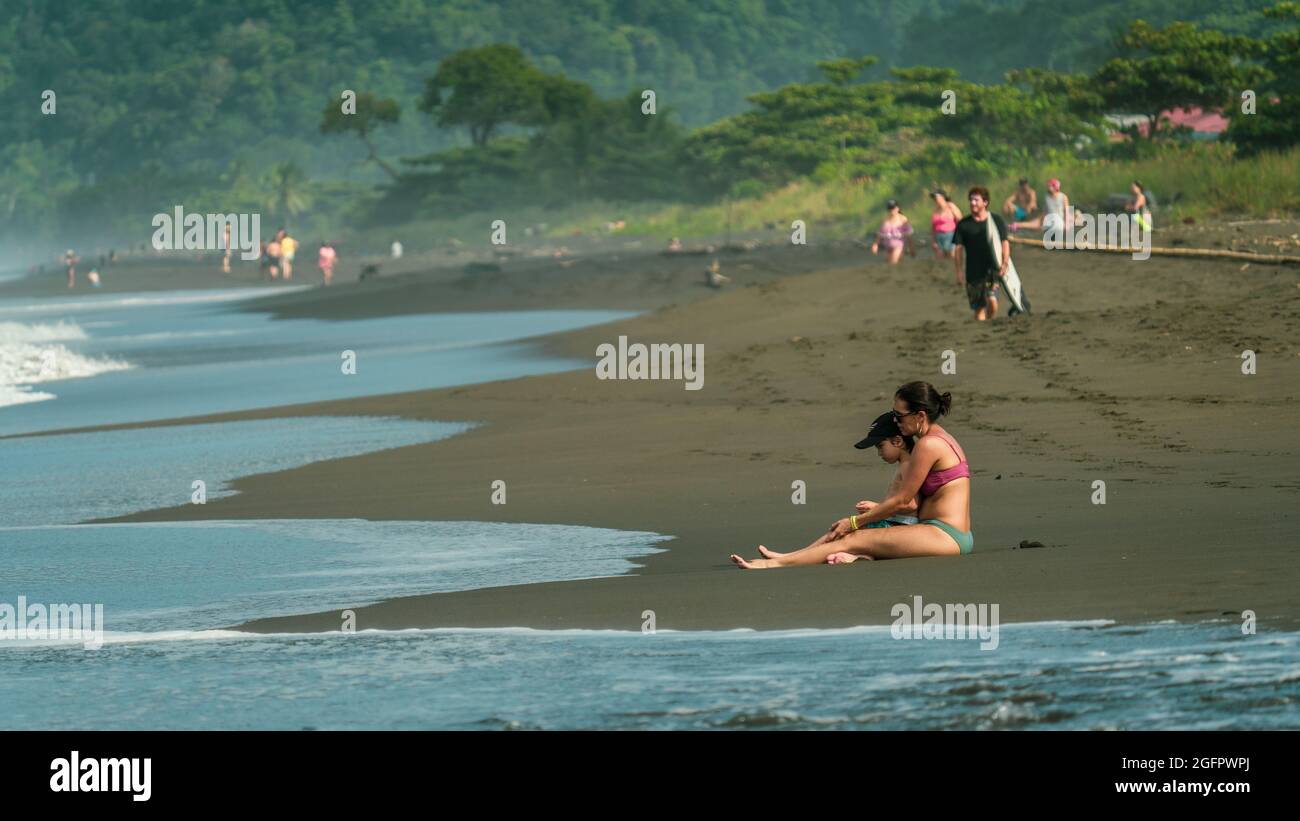 Eine Mutter und ihr Sohn sitzen und genießen einen heißen Tag an der Pazifikküste von Costa Rica Stockfoto
