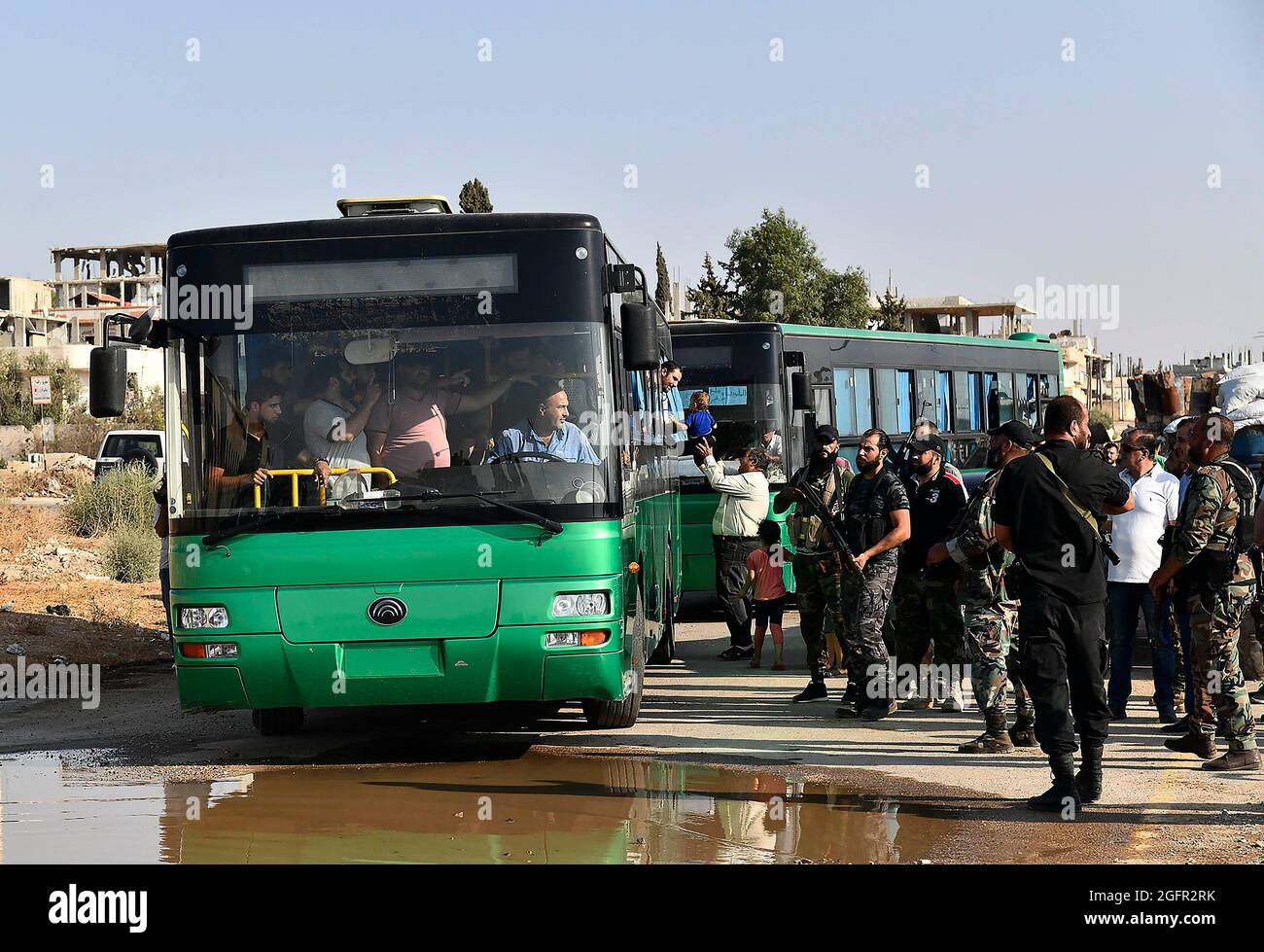 Daraa, Syrien. August 2021. Am 26. August 2021 werden in der südlichen Provinz von Syrien, Daraa, bewaffnete Männer vor Ort in Bussen gesehen. Eine Gruppe von bewaffneten Männern aus der südlichen syrischen Provinz Daraa wurde am Donnerstag im Rahmen eines russisch-vermittelten Abkommens in die von Rebellen gehaltenen Gebiete im Norden Syriens evakuiert, um monatelange Spannungen zu entschärfen, berichtete die staatliche Nachrichtenagentur SANA. Quelle: Str/Xinhua/Alamy Live News Stockfoto