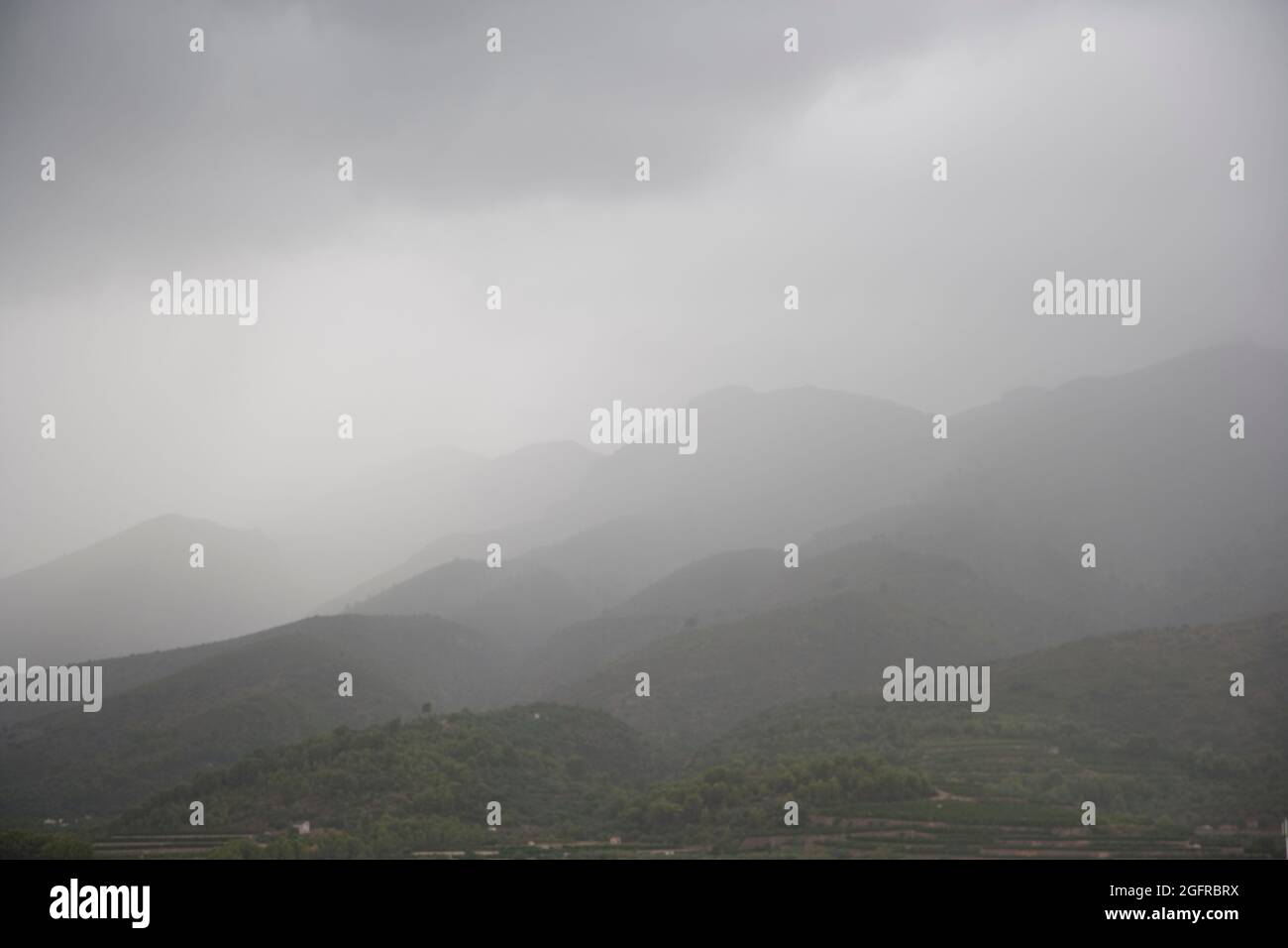 Nebel und niedrige Wolken um die Berge im Sommer, in der Nähe von Orba, Alicante, Spanien Stockfoto
