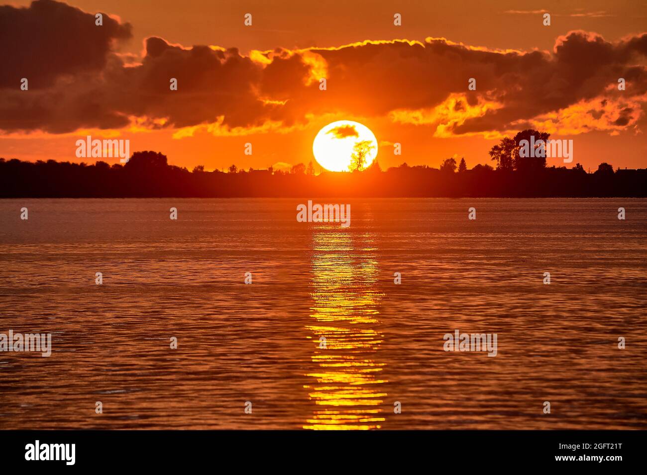 Sonnenuntergang auf dem Fluss, große Sonne Stockfoto