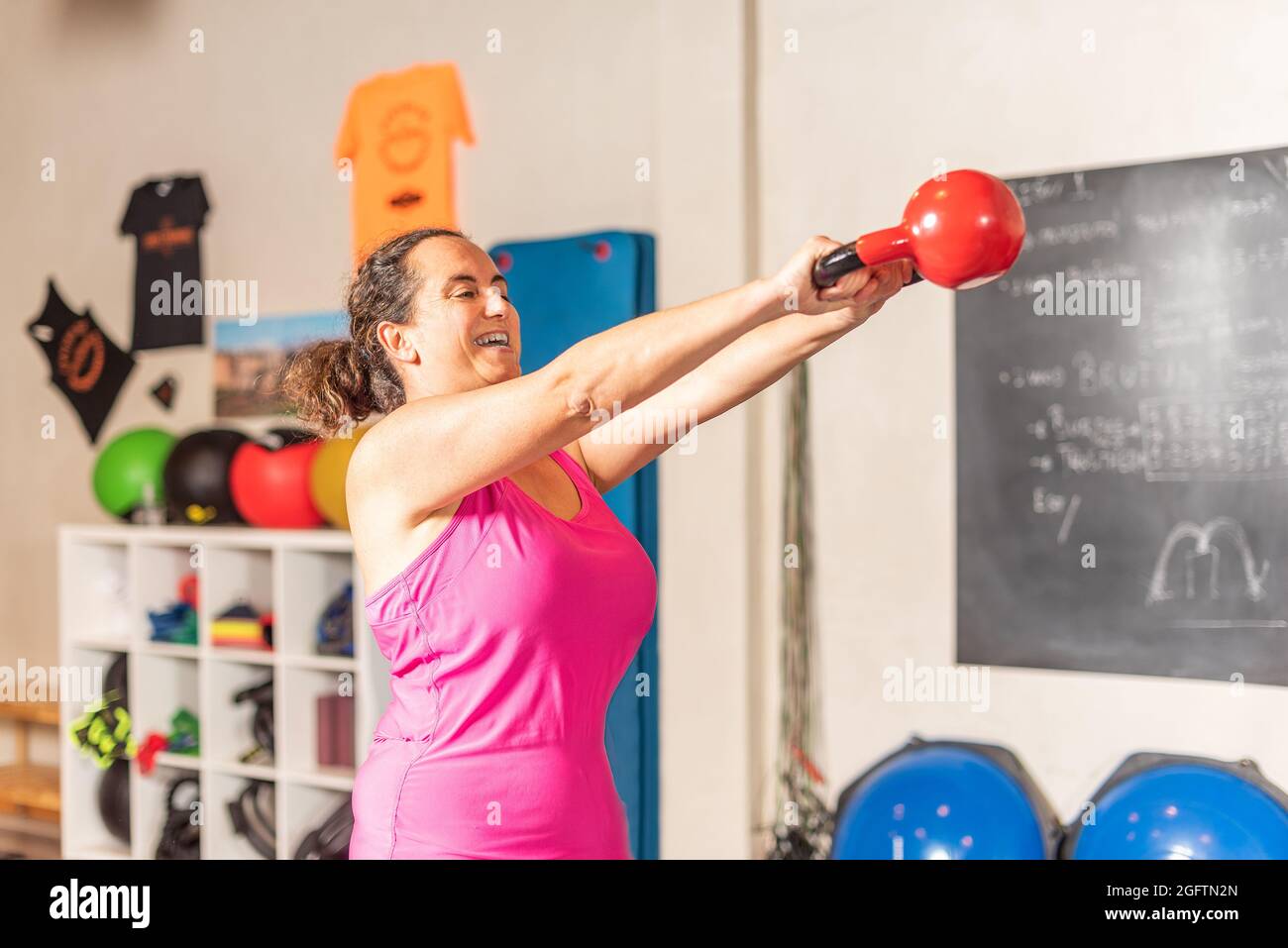 Frau tut Kettlebell Swing Übung im Fitnessstudio Stockfoto