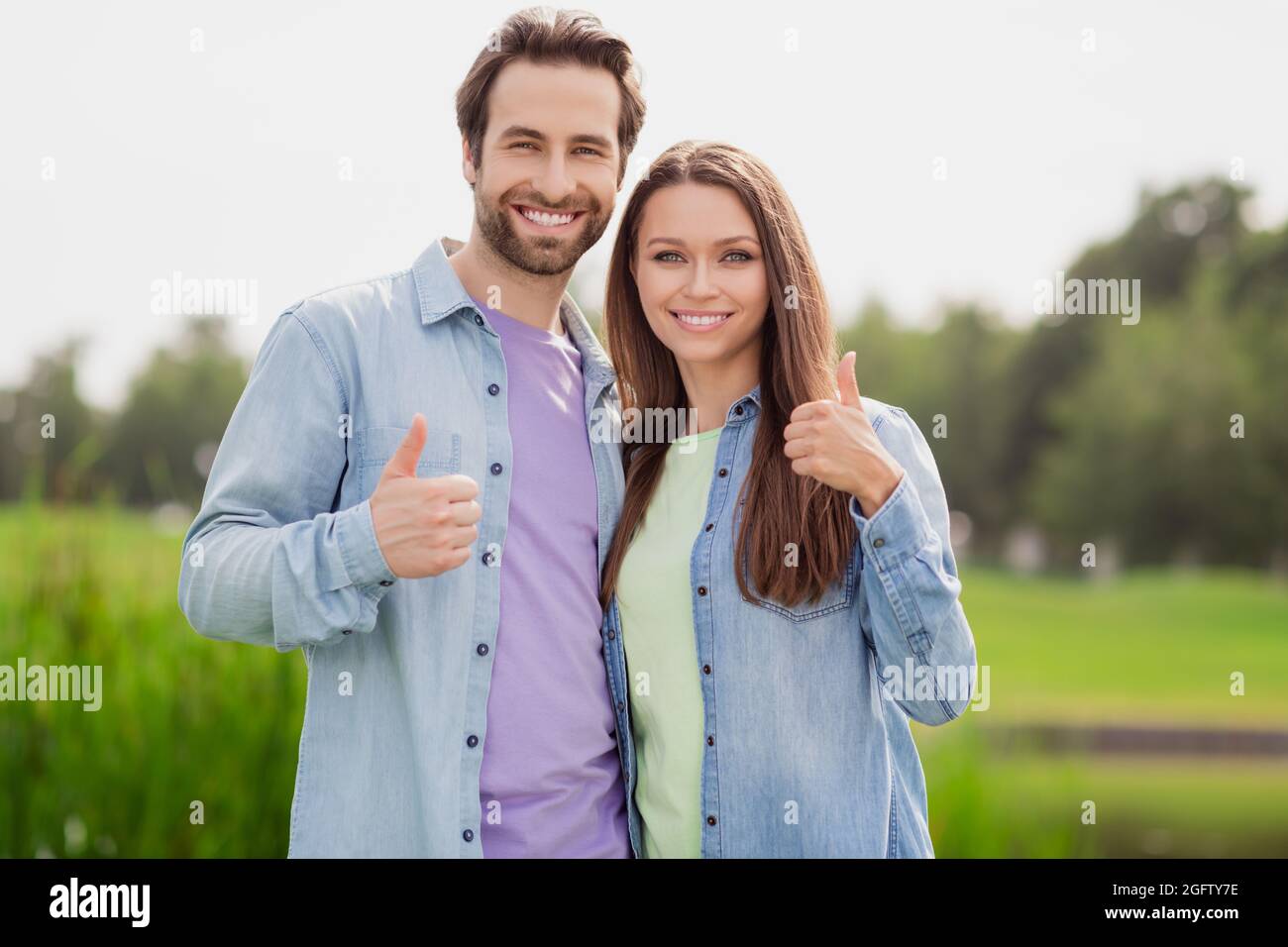 Foto von lächelnd fröhlich positive Paar Frau und Mann zeigen Daumen-up empfehlen Produkt werben Produkt entspannen im Freien Stockfoto