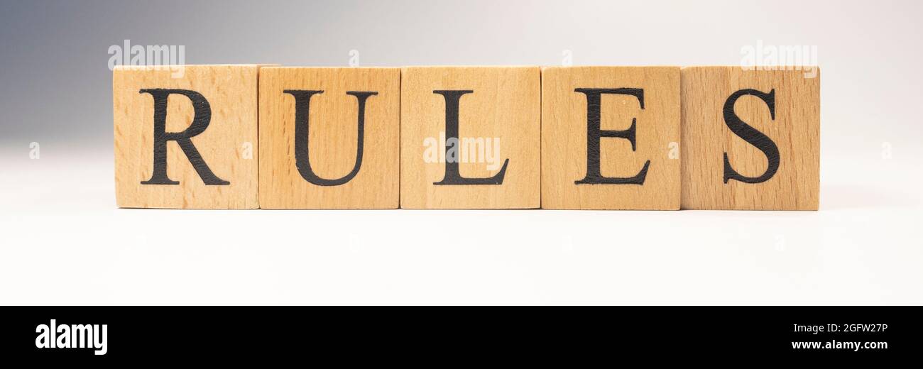 Das Wort Regeln wurde aus Holzwürfeln geschaffen. Gesetze und den Staat. Nahaufnahme. Stockfoto