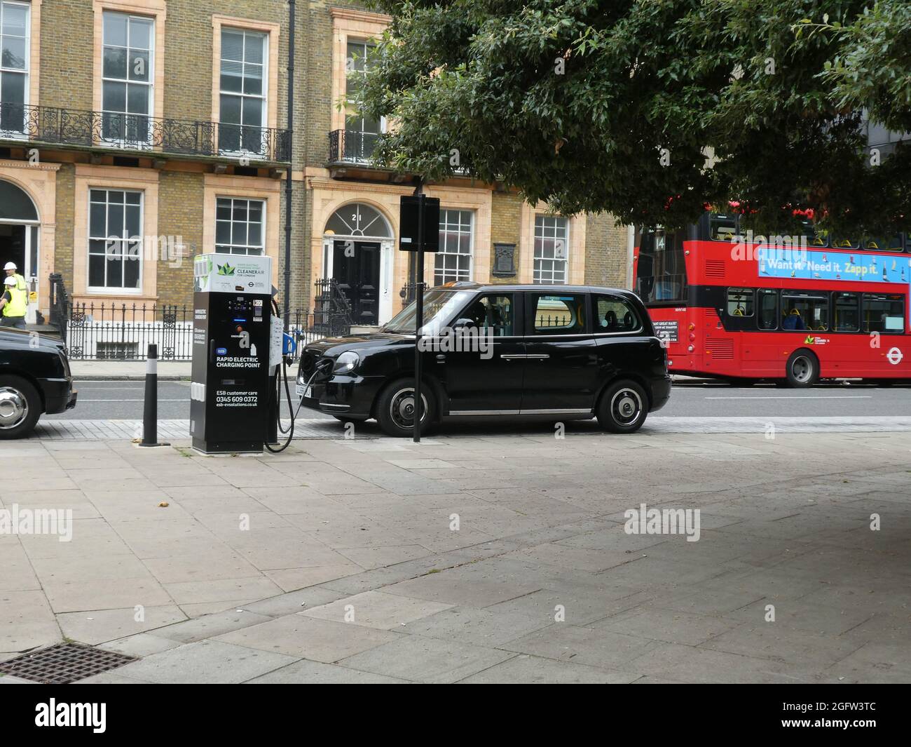 Ein schwarzes elektrisches Londoner Taxi sah, wie es an einer öffentlichen Ladestation in London aufgeladen wurde Stockfoto