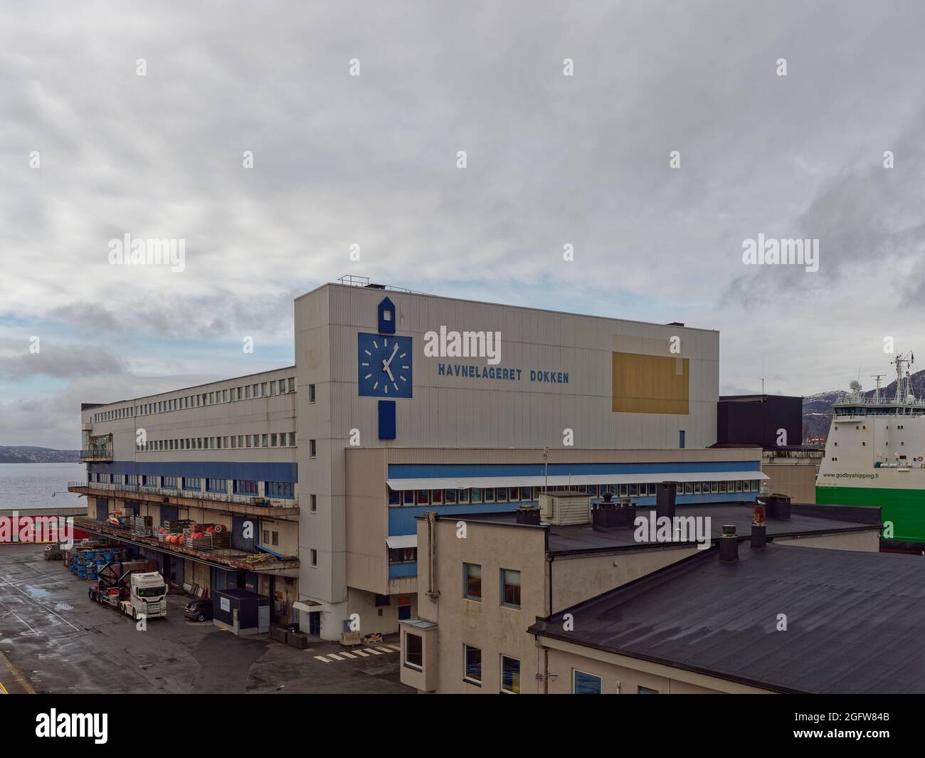 Das Bürogebäude Havnelagert Dokken im Hafen von Bergen an einem winterlichen Tag mit seiner großen minimalistischen Uhr an der Vorderseite des Gebäudes. Stockfoto