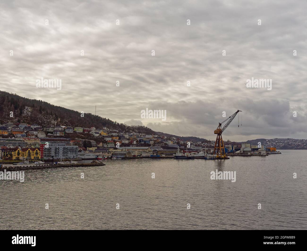 Apartments, Häuser und Maritime Gebäude, die sich unter dem Winterhimmel am Ufer des Hafens von Bergen vermischen. Stockfoto
