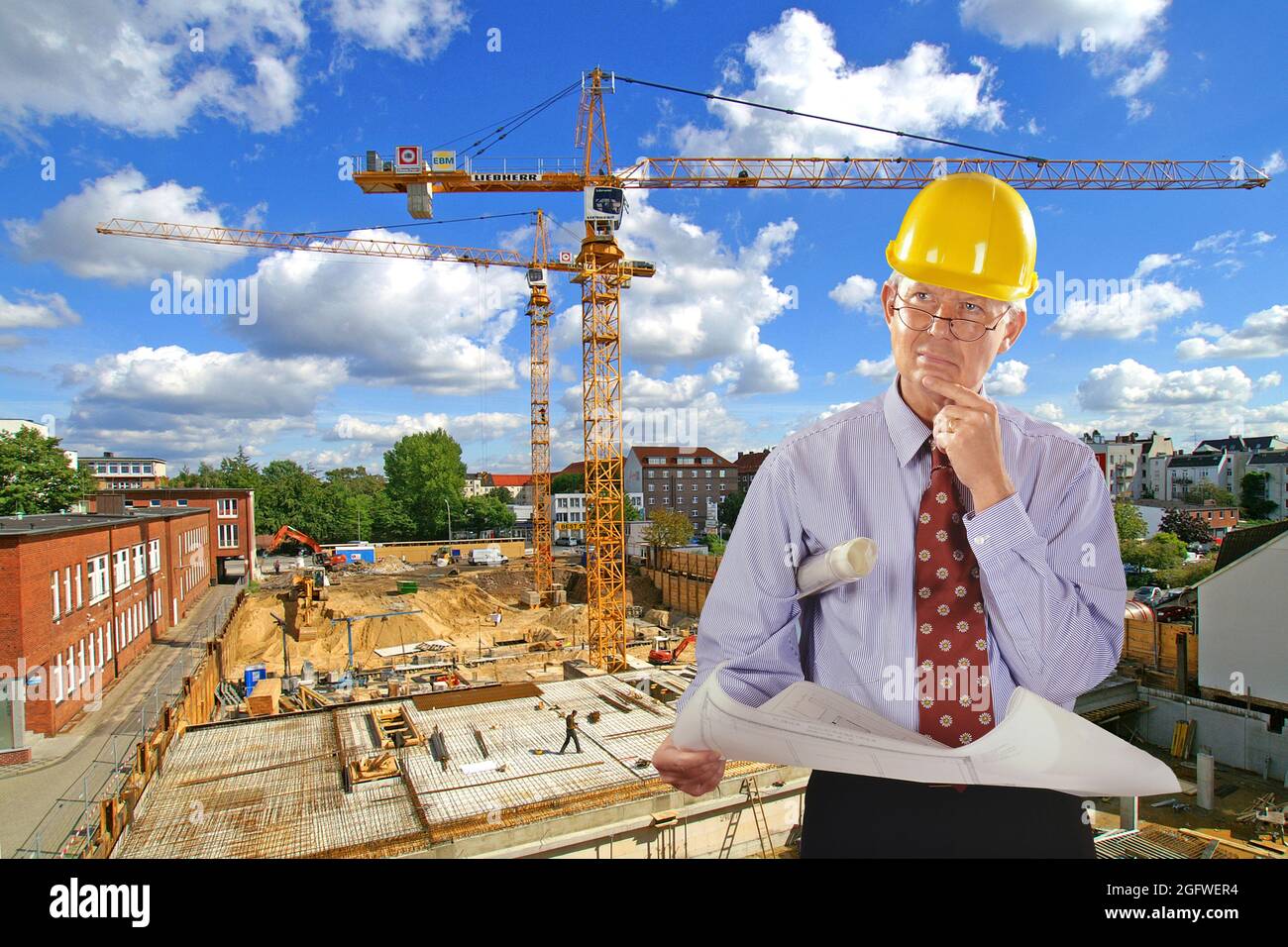 Architekt mit Bauplan und Hut, Baustelle im Hintergrund Stockfoto