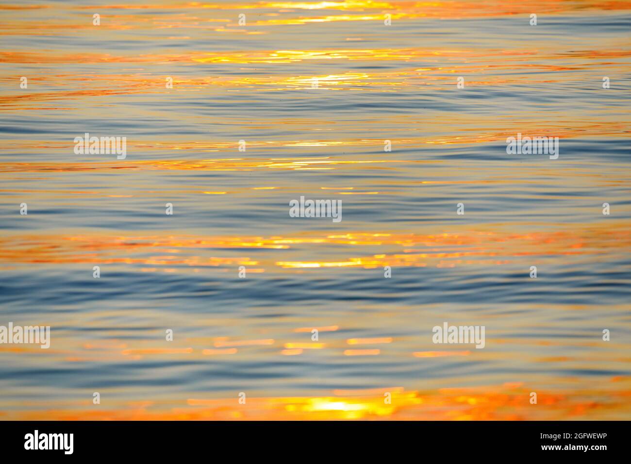 Sonnenstrahlen, die sich bei Sonnenaufgang auf der Wasseroberfläche des Bodensees spiegeln und ein abstraktes Muster bilden, Schweiz Stockfoto