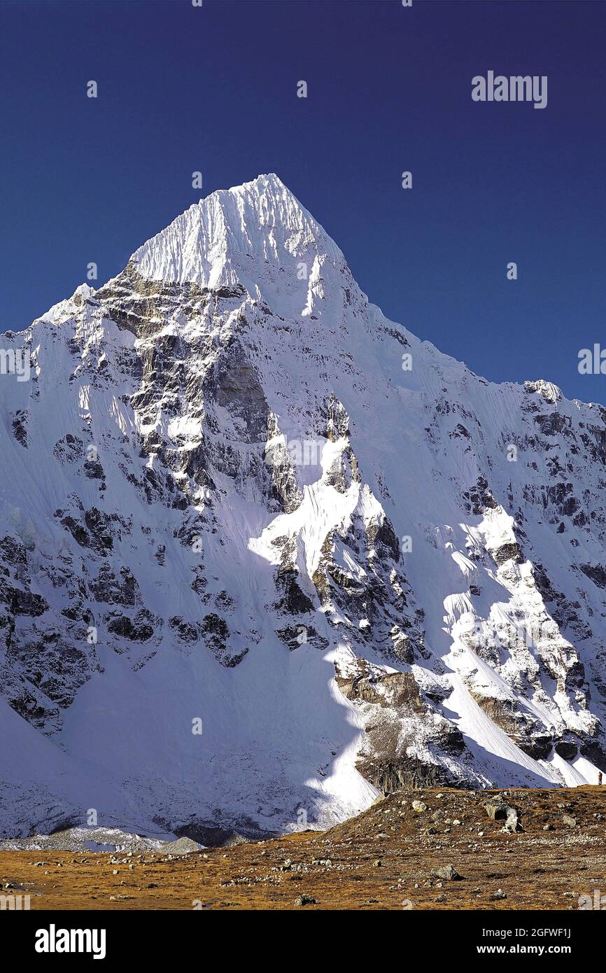 Wedge Peak aus Pang Pema in der Region Kangchendzönga im Osten Nepals. Kleine menschliche Figur, die unten rechts zu sehen ist, Nepal, Kangchendzönga, Wedge Peak Stockfoto