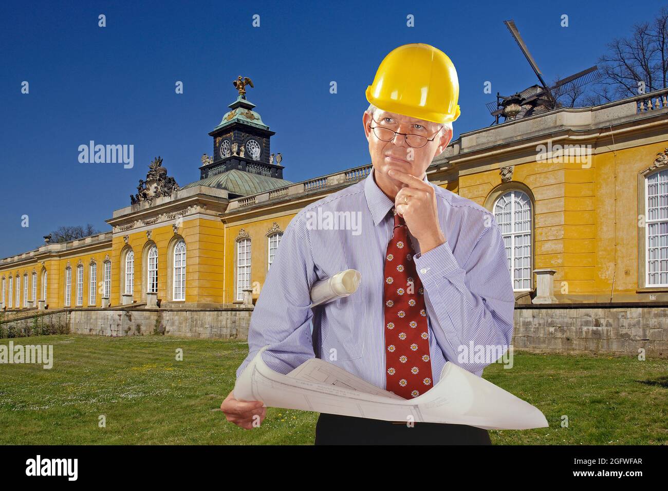 Architekt mit Bauplan und Hut vor einem alten Schloss Stockfoto