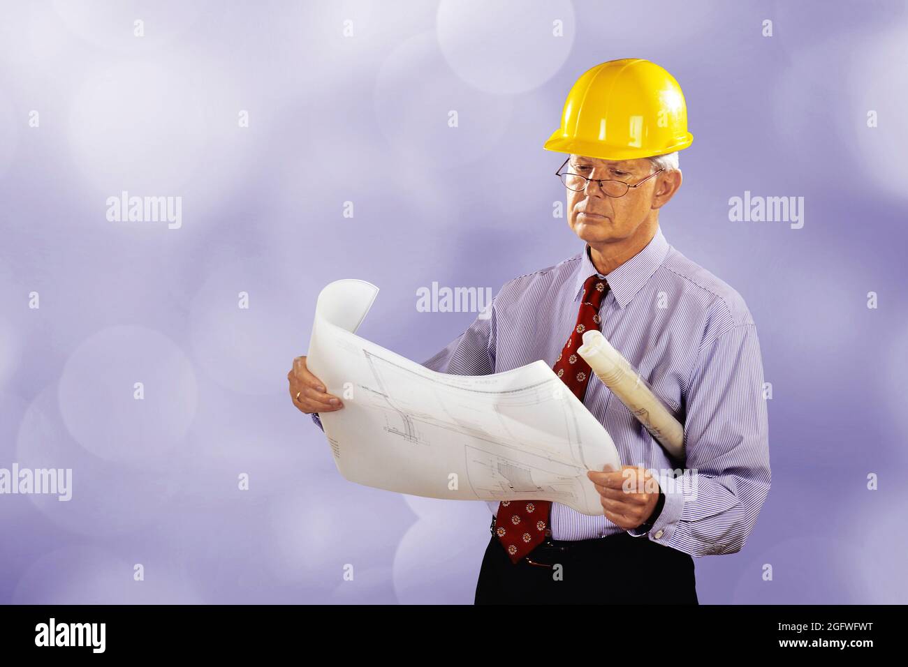 Architekt mit Bauplan und Hut, verschwommener Hintergrund Stockfoto