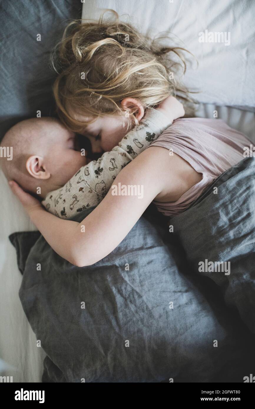 Mädchen schlafen mit Baby Geschwister Stockfoto