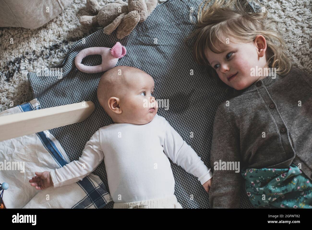 Mädchen mit Baby Geschwister, die einander angucken Stockfoto