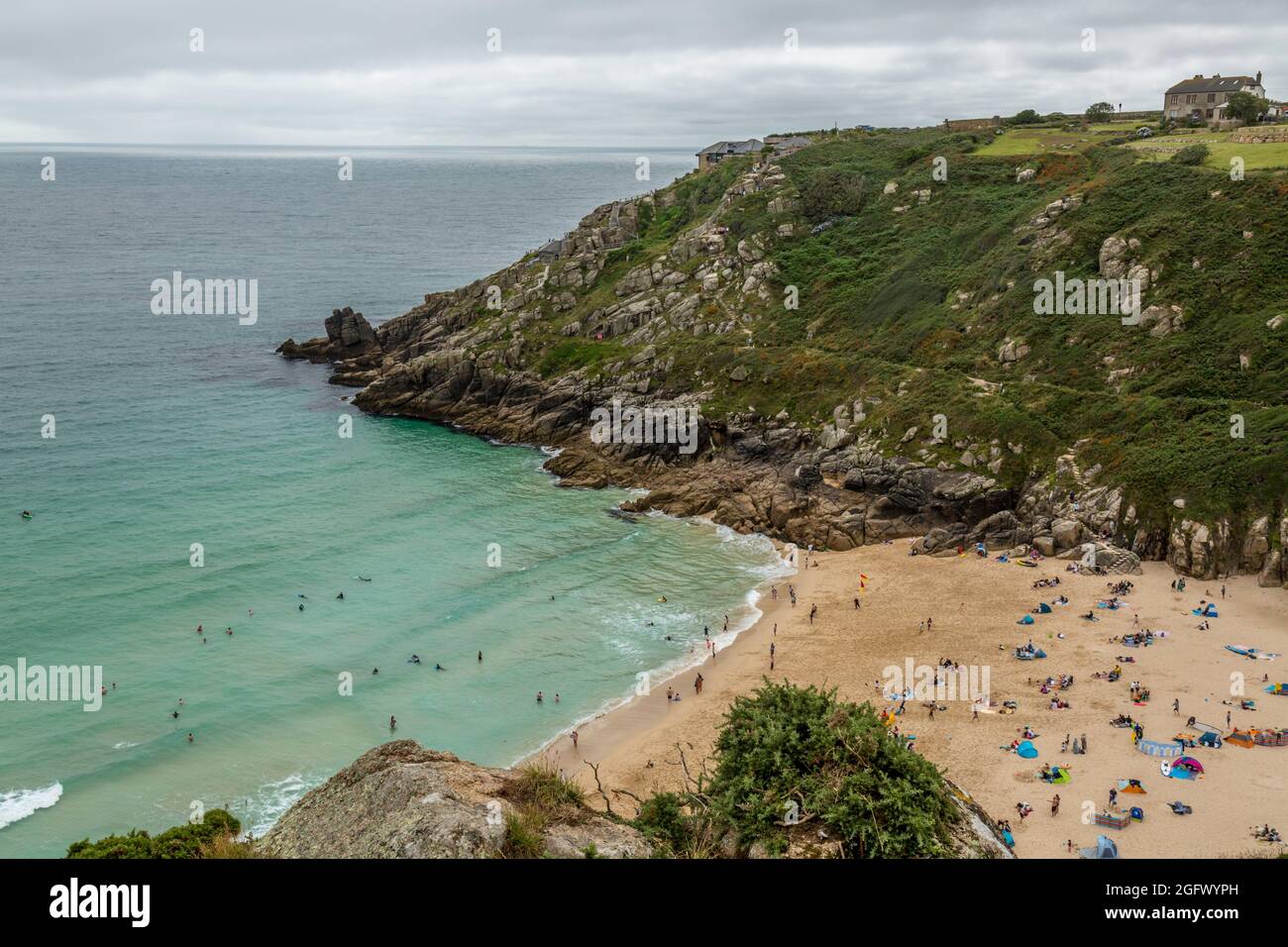 Porthcurno Beach in Cornwall, England, mit dem Minack Theatre auf der Landzunge. Stockfoto