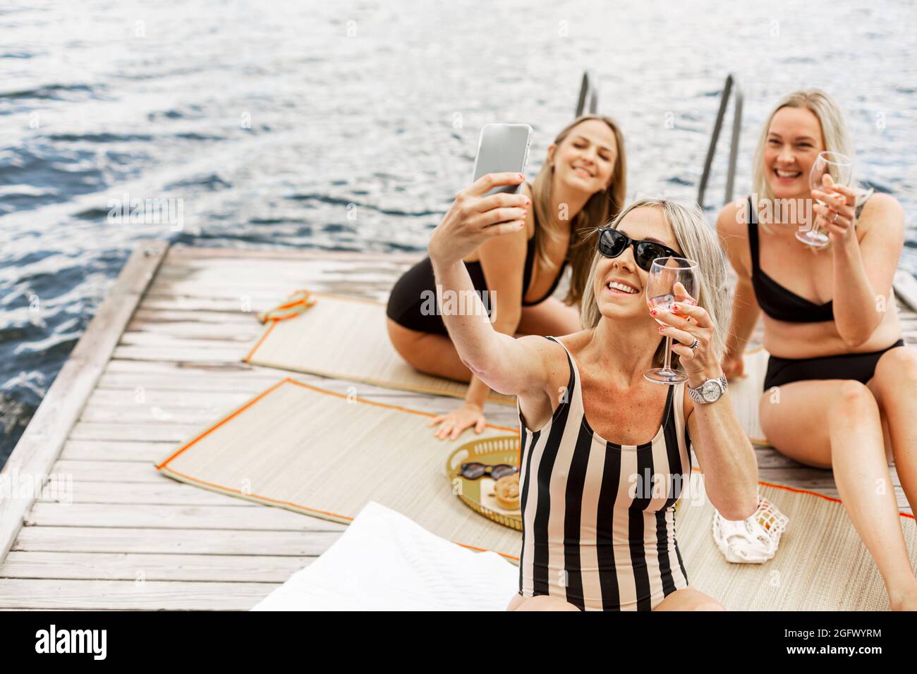 Glückliche Frau, die sich auf dem Steg entspannt Stockfoto