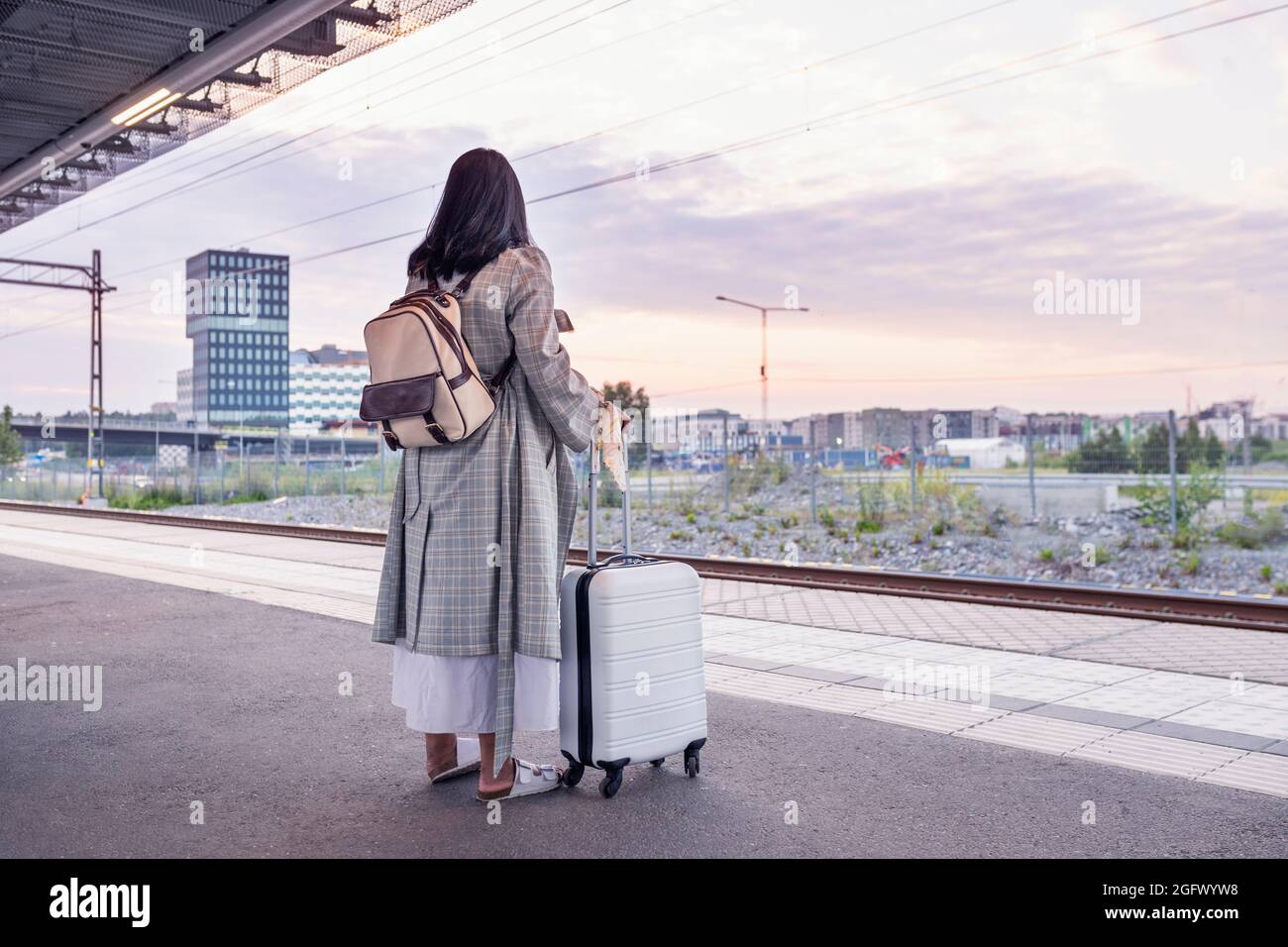 Frau wartet am Bahnhofsplatz Stockfoto