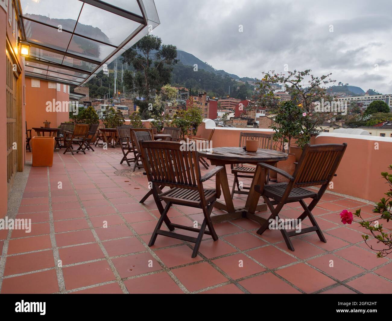 Bogota, Kolumbien - September 2017: Terrasse im Hotel mit Holztischen und -Stühlen und Blick auf die Monserrate-Hügel. Südamerika Stockfoto