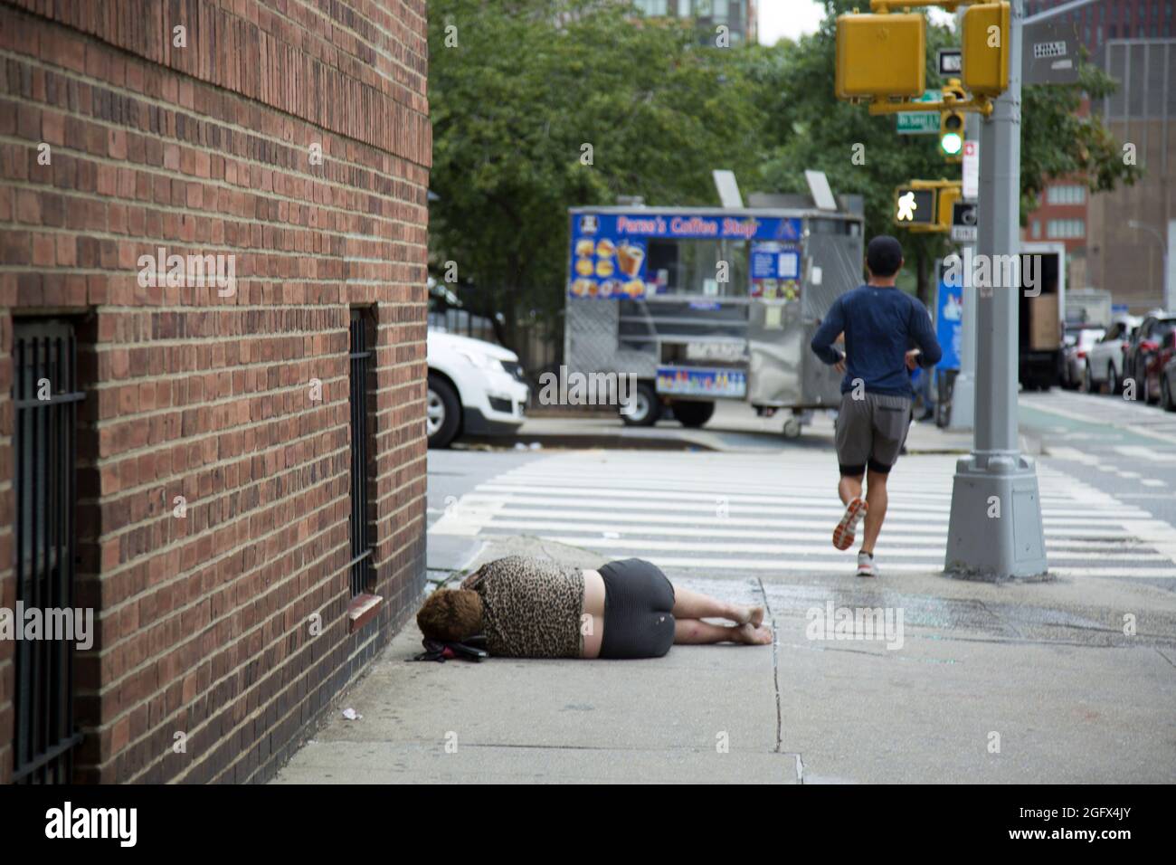 Es ist üblich, dass Menschen, Obdachlose, psychisch Kranke und Alkoholiker auf dem Bürgersteig in ganz Manhattan schlafen; New York City. Es ist ein trauriger Kommentar darüber, wie gut wir unsere schwächsten Bürger behandeln. Stockfoto