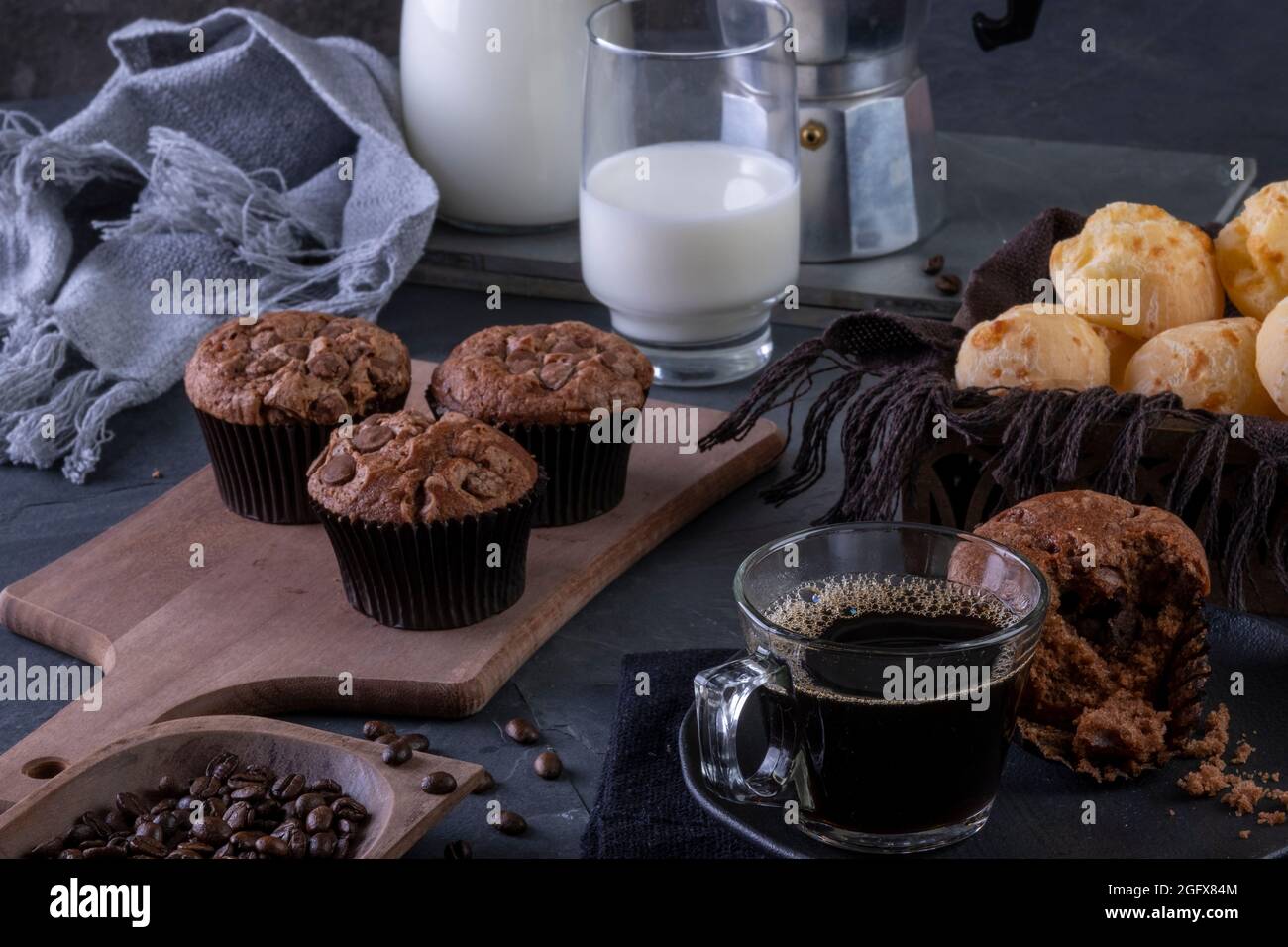 Eine Tasse Kaffee, Schokoladenmuffins, Käsebrot und Milch. Stockfoto