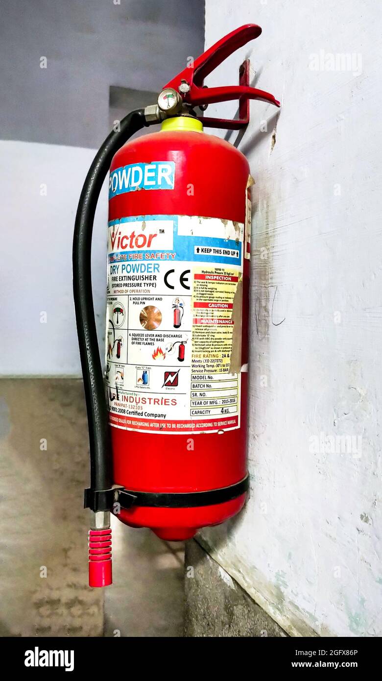 Hisar, Haryana august 2021 : roter Feuerlöscher, der an der Wand hängt Stockfoto