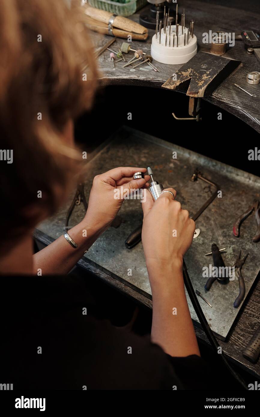Über der Schulter Blick auf nicht erkennbare Herstellung Juwelier Polieren Silberring in der Werkstatt Stockfoto