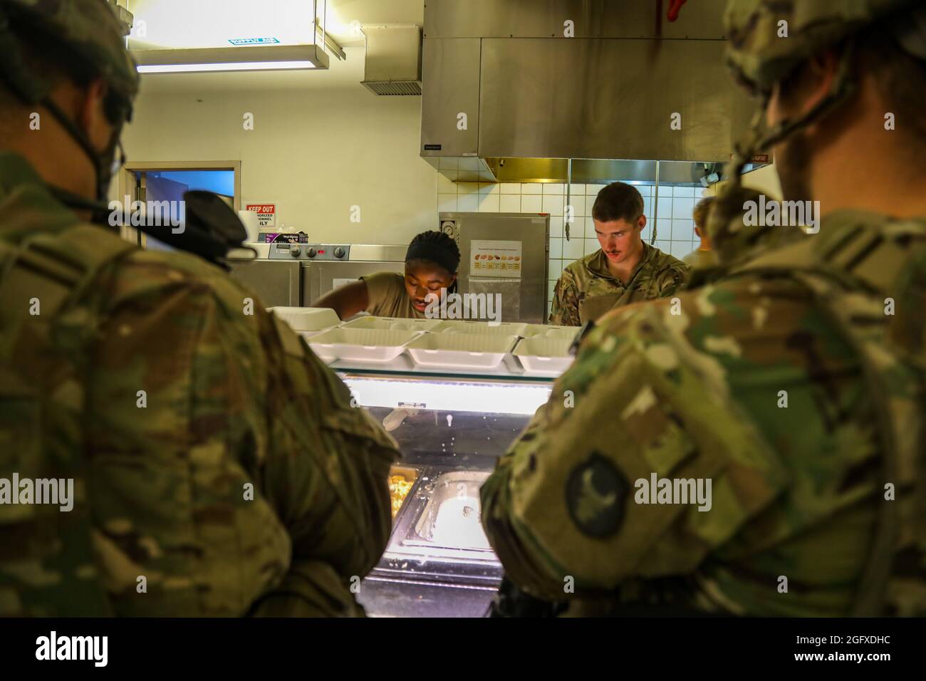 Köche der US-Armee servieren Soldaten, die zur Unterstützung einer nicht-kämpferischen Evakuierungsoperation in Kabul, Afghanistan, eingesetzt wurden, Nahrung, 25. August 2021. (USA Armeefoto von Sgt. Jillian G. Hix) Stockfoto