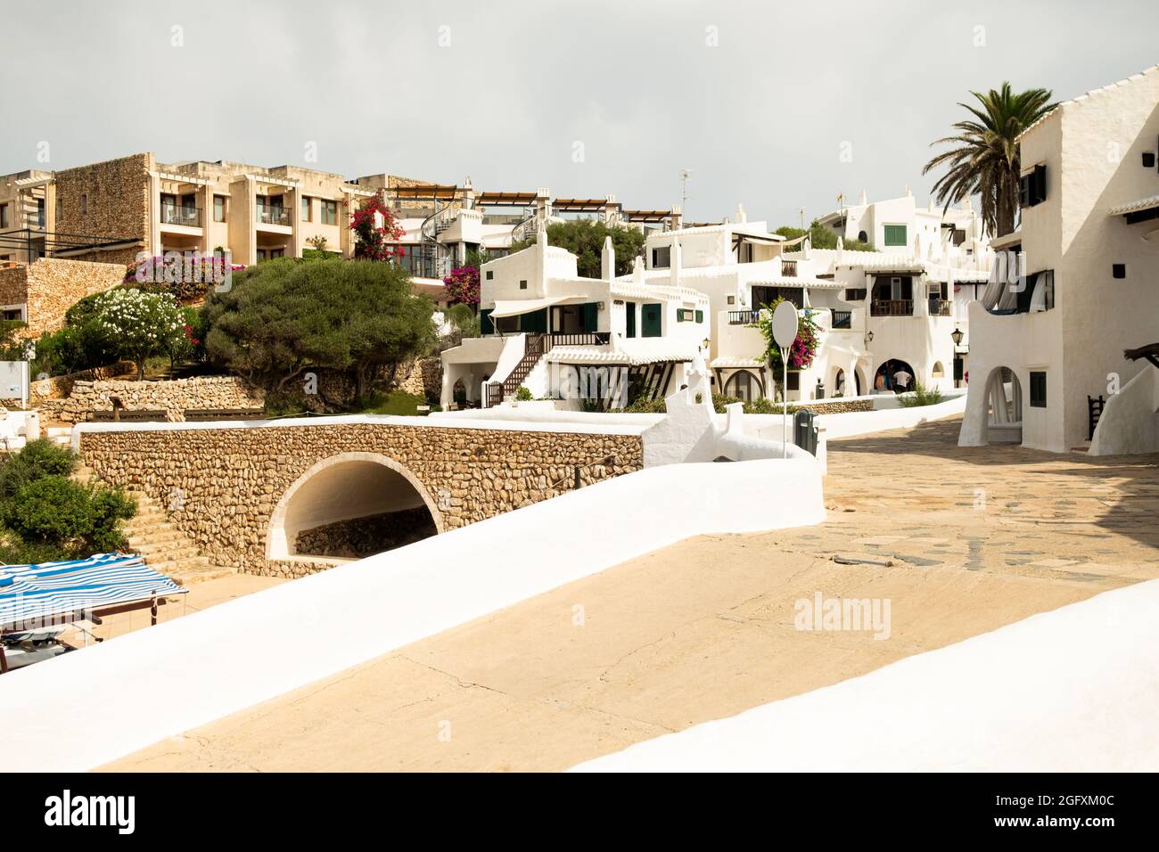Blick auf die Gassen und weißen Architektur und Gebäude des Fischerdorfes Binibeca Vell, Menorca, Spanien während der Sommersaison. Stockfoto