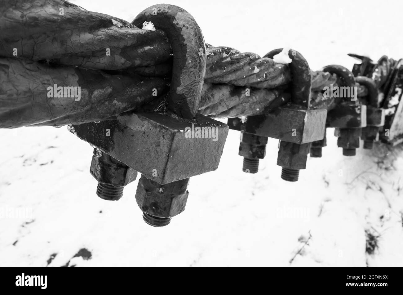 Schwarzes Stahlseil mit Endbefestigungsschlössern, Schwarz-Weiß-Foto mit selektivem Fokus Stockfoto