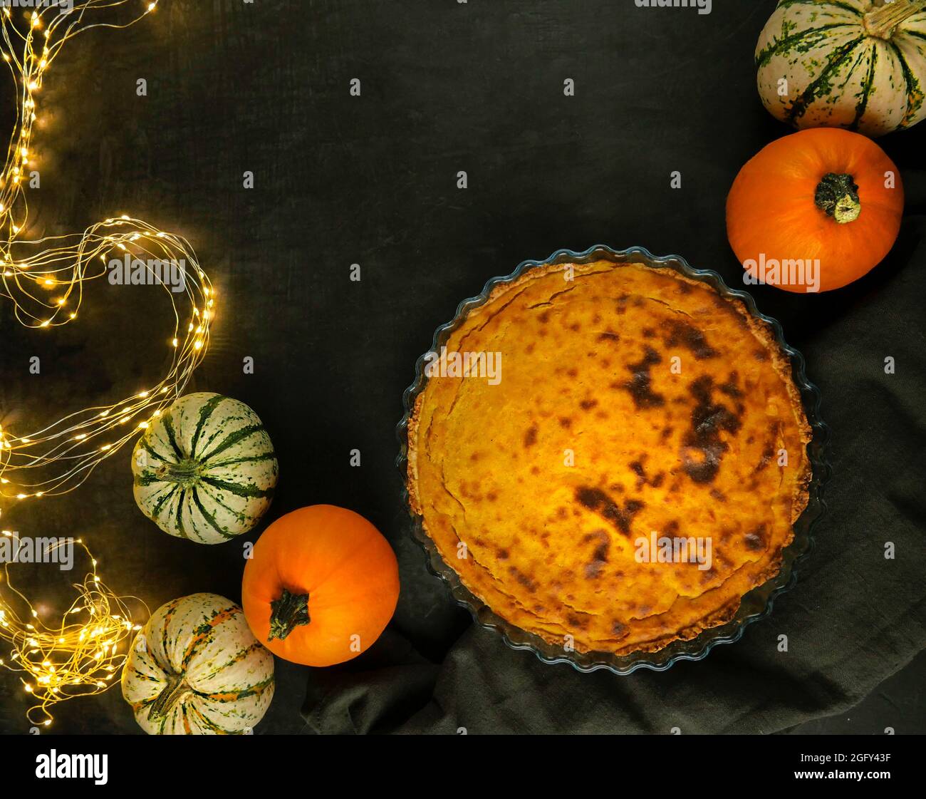 Thanksgiving Abendessen Festlicher Tisch. Kürbiskuchen. Mehrfarbige Kürbisse und beleuchtete Lichter. Blick von oben Stockfoto