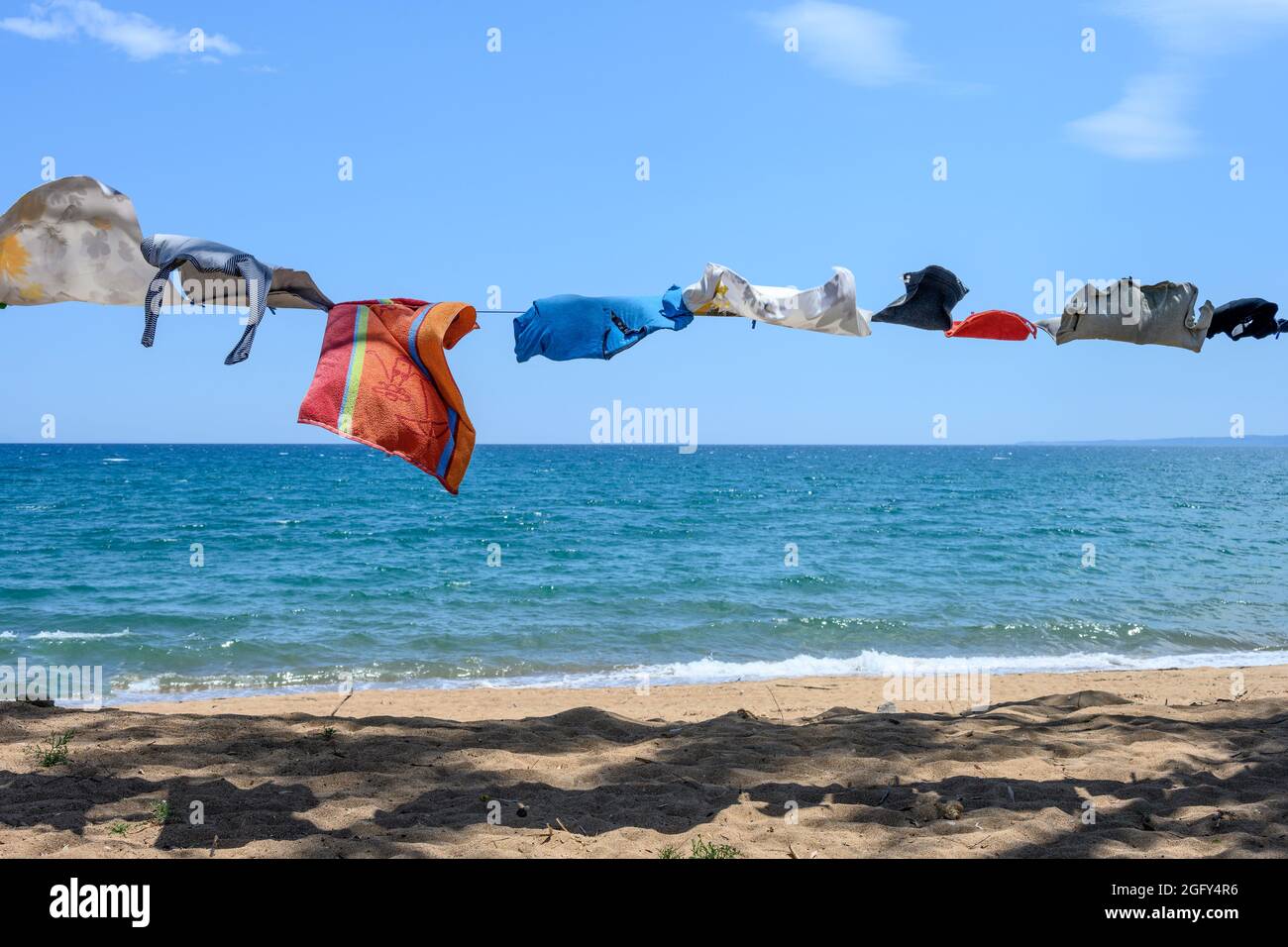 Camper Kleidung auf einer Wäscheleine neben dem Meer an einem Strand in Südgriechenland. Stockfoto