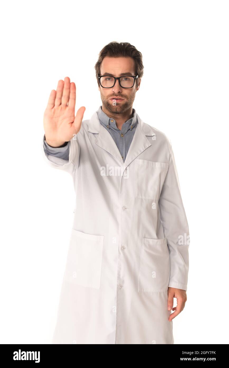 Junger Arzt zeigt Stoppgeste isoliert auf Weiß Stockfoto