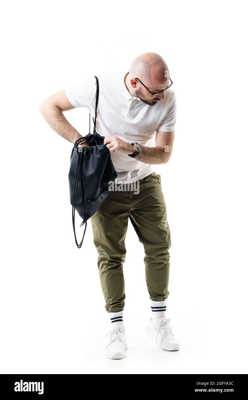 Verwirrt junge kahlrasierte nerdy Mann Suche Tasche nach vergessenen oder verlorenen Artikel. Porträt in voller Länge isoliert auf weißem Hintergrund Stockfoto Verwirrt junge kahlrasierte nerdy Mann Suche Tasche nach vergessenen oder verlorenen Artikel. Porträt in voller Länge isoliert auf weißem Hintergrund Stockfoto