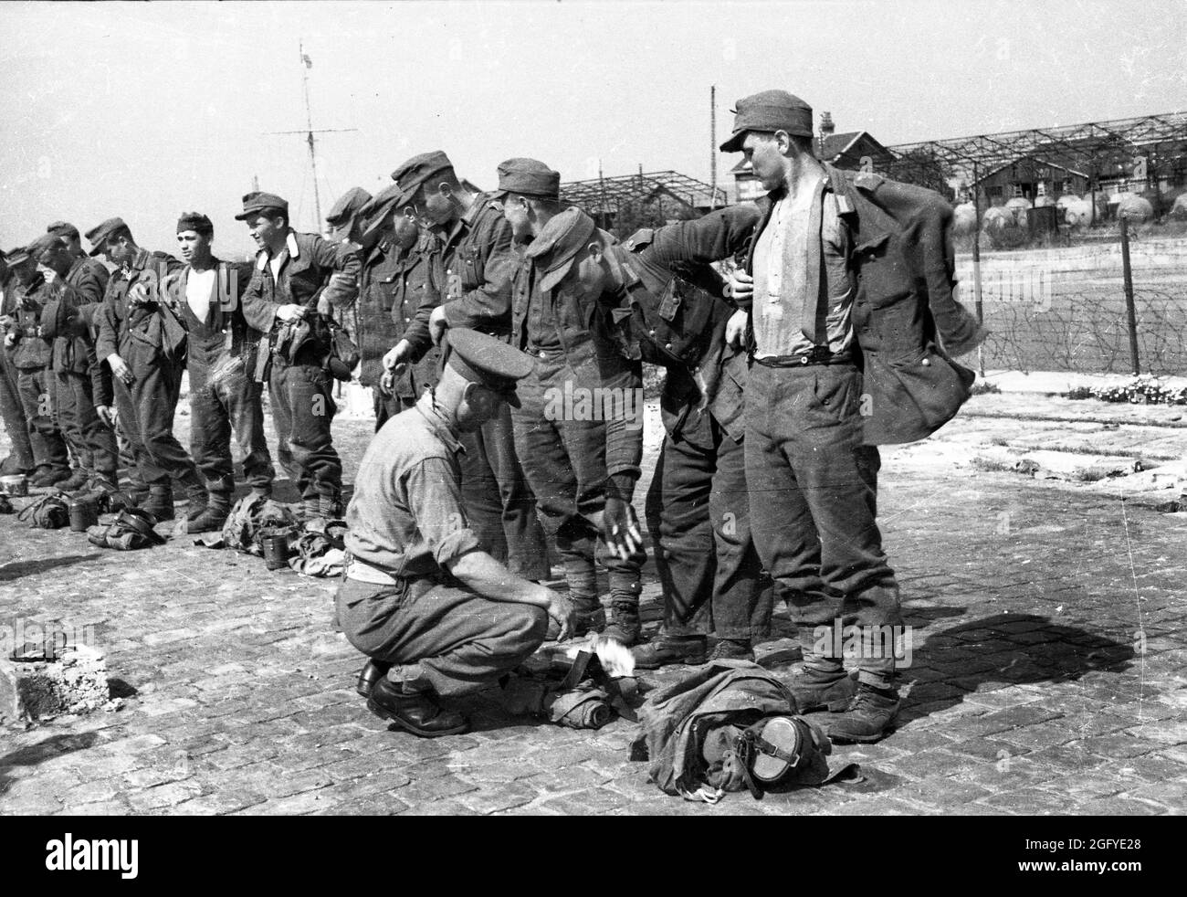 Die Befreiung von Honfleur, Normandie, Frankreich während des zweiten Weltkrieges. 26. August 1944. Ein britischer Soldat sucht nach der Kapitulation junge deutsche Soldaten. Stockfoto