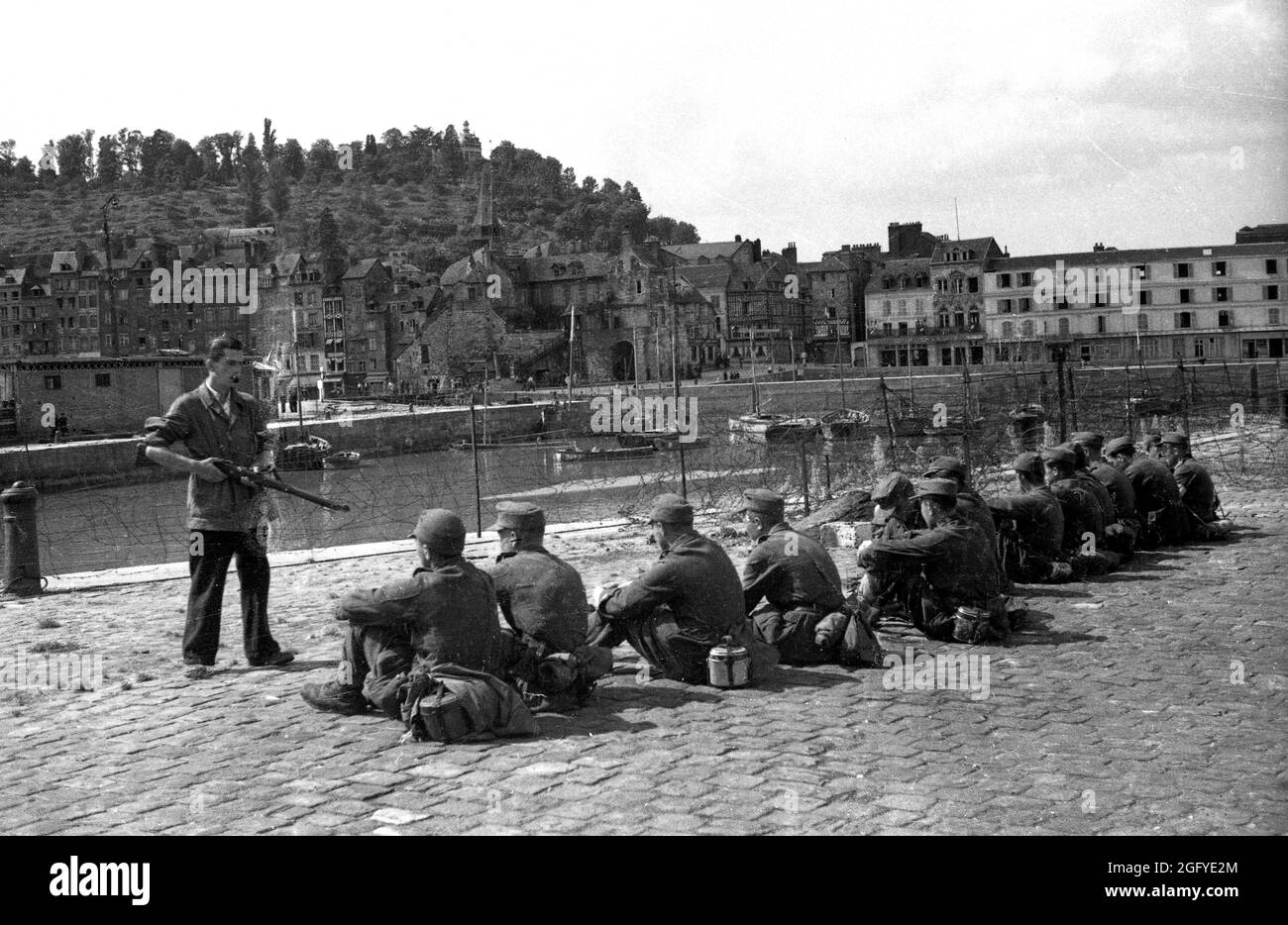 Die Befreiung von Honfleur, Normandie, Frankreich während des zweiten Weltkrieges. 26. August 1944. Ein französischer Widerstandskämpfer bewacht junge deutsche Soldaten nach ihrer Kapitulation. Stockfoto