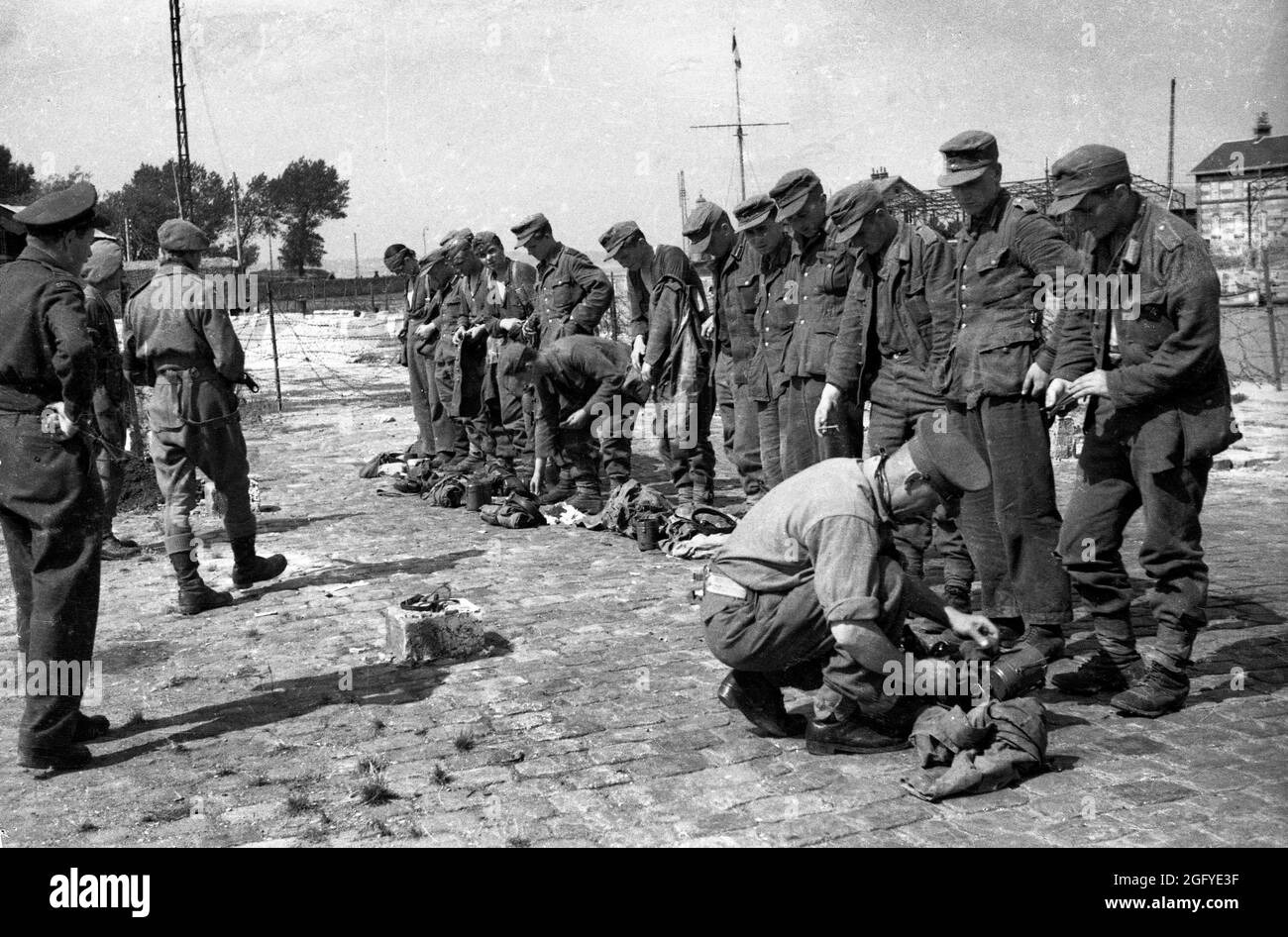 Die Befreiung von Honfleur, Normandie, Frankreich während des zweiten Weltkrieges. 26. August 1944. Britische und kanadische Soldaten suchen nach ihrer Kapitulation junge deutsche Soldaten. Stockfoto