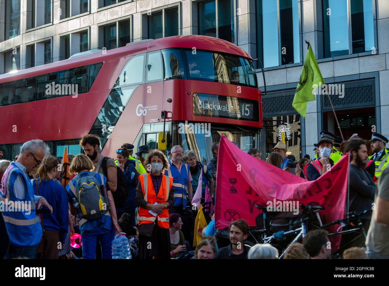 London, Großbritannien. 27. August 2021. Ein Doppeldeckerbus kann nirgendwo hinfahren, da die Straße von Extinction Rebellion-Aktivisten vor der U-Bahnstation Mansion House in der Queen Victoria Street in der City of London blockiert wird. Die Veranstaltung ist Teil des Protestes ‘Unmögliche Rebellion’, um „die Ursache der Klima- und Umweltkrise anzuvisieren“ und dauert zwei Wochen, bis die Regierung zustimmt, alle Investitionen in neue fossile Brennstoffe zu stoppen. Kredit: Stephen Chung / Alamy Live Nachrichten Stockfoto