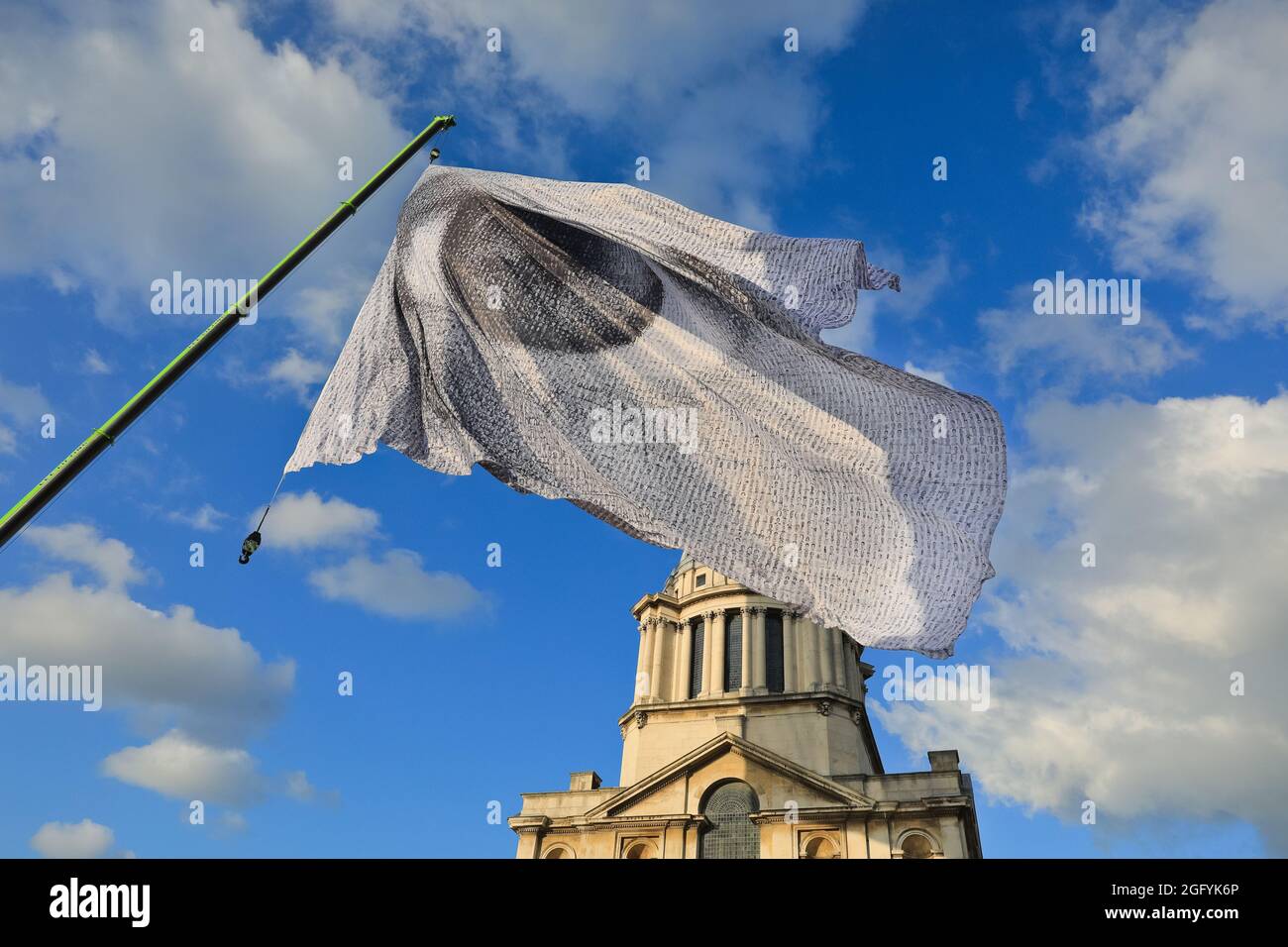 Greenwich, London, Großbritannien. August 2021. „We Are Watching“ von Dan Acher wird heute im Rahmen des Greenwich and Docklands International Festivals ins Leben gerufen. Die Riesenfahne ist ein monumentales Auge, das aus Tausenden von Porträts aus 190 Ländern besteht. Es fliegt hoch über dem Gelände und dem wunderschönen Gebäude des historischen Old Royal Naval College. Kredit: Imageplotter/Alamy Live Nachrichten Stockfoto