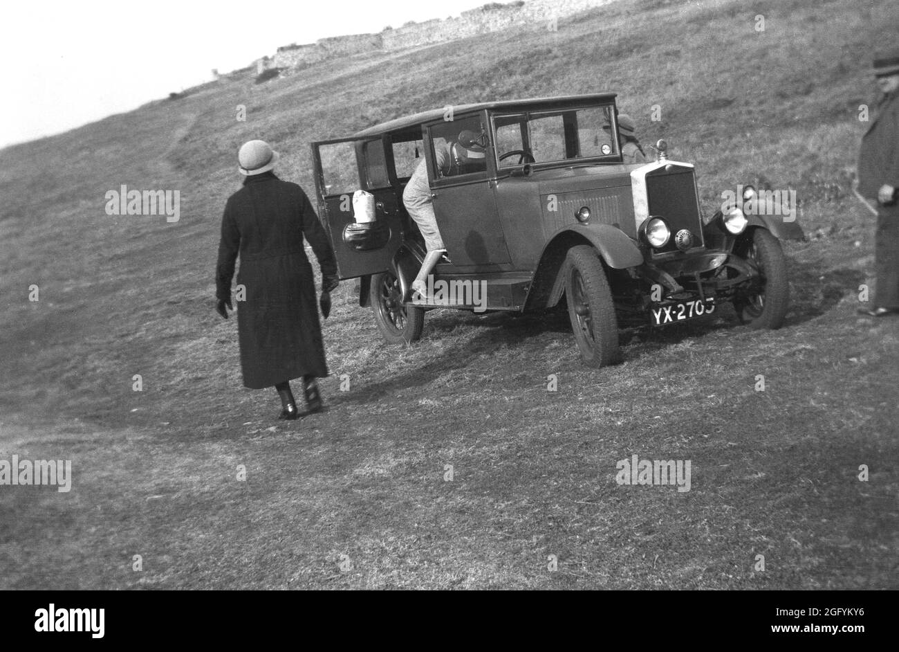 1930er Jahre, historisch, Autofahren, ein Tagesausflug, eine Dame, die in den Rücken eines Autos der Zeit geparkt draußen auf einem Hügel, England, Großbritannien. Stockfoto