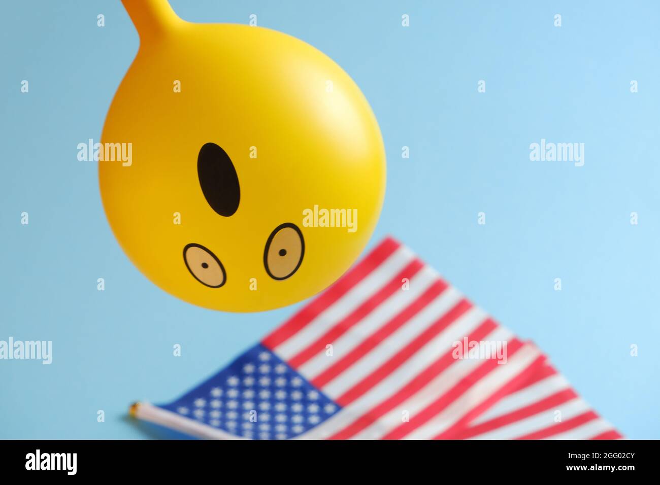 Gelbe Emoji-Ballons mit amerikanischen Flaggen auf blauem Hintergrund. Geburtstag des Emoticons. Stockfoto