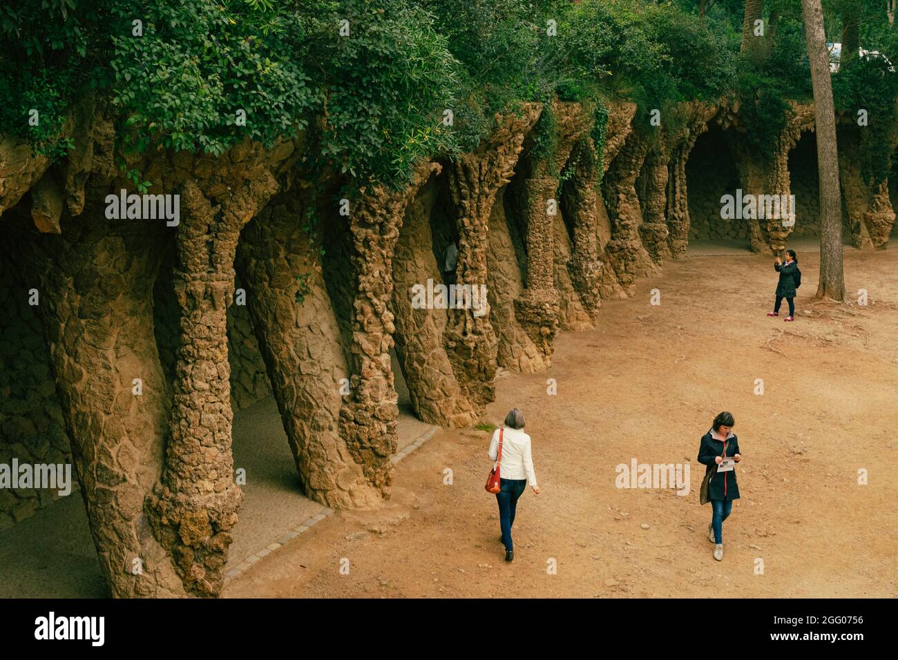 Besucher des einzigartigen Steinsäulenviadukts im Parc Güell, entworfen vom Architekten Antoni Gaudi, Barcelona, Katalonien, Spanien Stockfoto