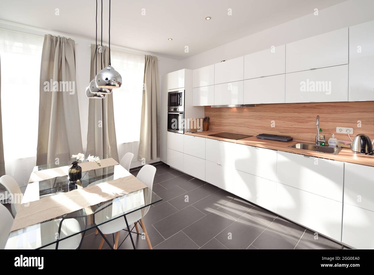 Schöne frische weiße Licht Küche weit offene große Holz innen silberfarbene Lampe auf Esstisch Stockfoto