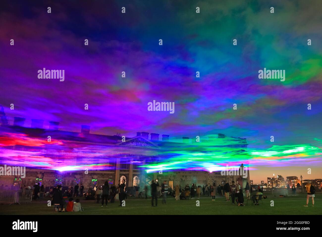 Greenwich, London, Großbritannien. August 2021. Die Menschen beobachten das Spektakel. An seiner offiziellen öffentlichen Startnacht beleuchtet „Borealis“ von Dan Archer den Himmel über dem Old Royal Naval College im Royal Borough of Greenwich. „Borealis“ ist eine faszinierende Nachbildung der Nordlichter am Himmel. Es ist Teil des jährlichen Greenwich and Docklands Festivals, das vom 27. August bis 11. September 2021 stattfindet. Kredit: Imageplotter/Alamy Live Nachrichten Stockfoto