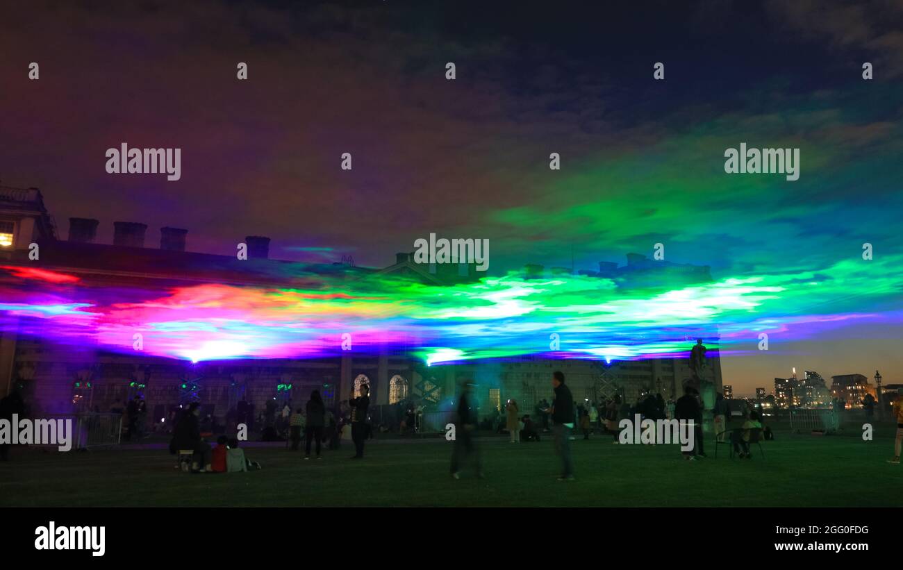Greenwich, London, Großbritannien. August 2021. Die Menschen beobachten das Spektakel. An seiner offiziellen öffentlichen Startnacht beleuchtet „Borealis“ von Dan Archer den Himmel über dem Old Royal Naval College im Royal Borough of Greenwich. „Borealis“ ist eine faszinierende Nachbildung der Nordlichter am Himmel. Es ist Teil des jährlichen Greenwich and Docklands Festivals, das vom 27. August bis 11. September 2021 stattfindet. Kredit: Imageplotter/Alamy Live Nachrichten Stockfoto
