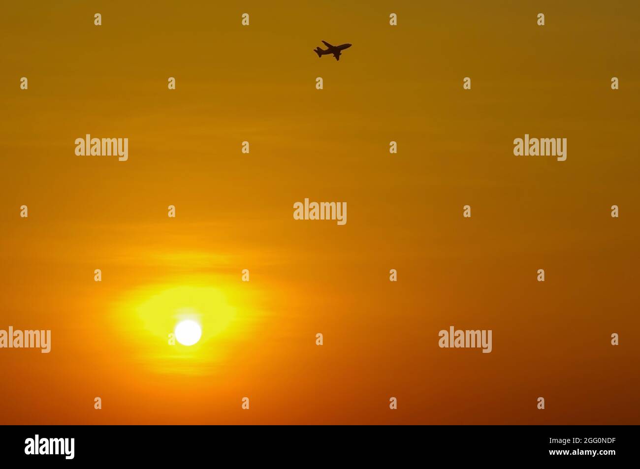 Silhouette eines Flugzeugs, das bei Sonnenuntergang fliegt, flacher Fokus Stockfoto
