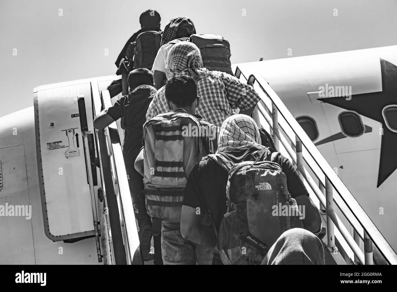 Evakuierte besteigen ein Flugzeug zur Evakuierung am Hamid Karzai International Airport, Afghanistan, August 25. US-Dienstmitglieder unterstützen das Außenministerium bei einer nicht-kämpferischen Evakuierungsoperation (NEO) in Afghanistan. (USA Marine Corps Foto von CPL. Davis Harris) Stockfoto
