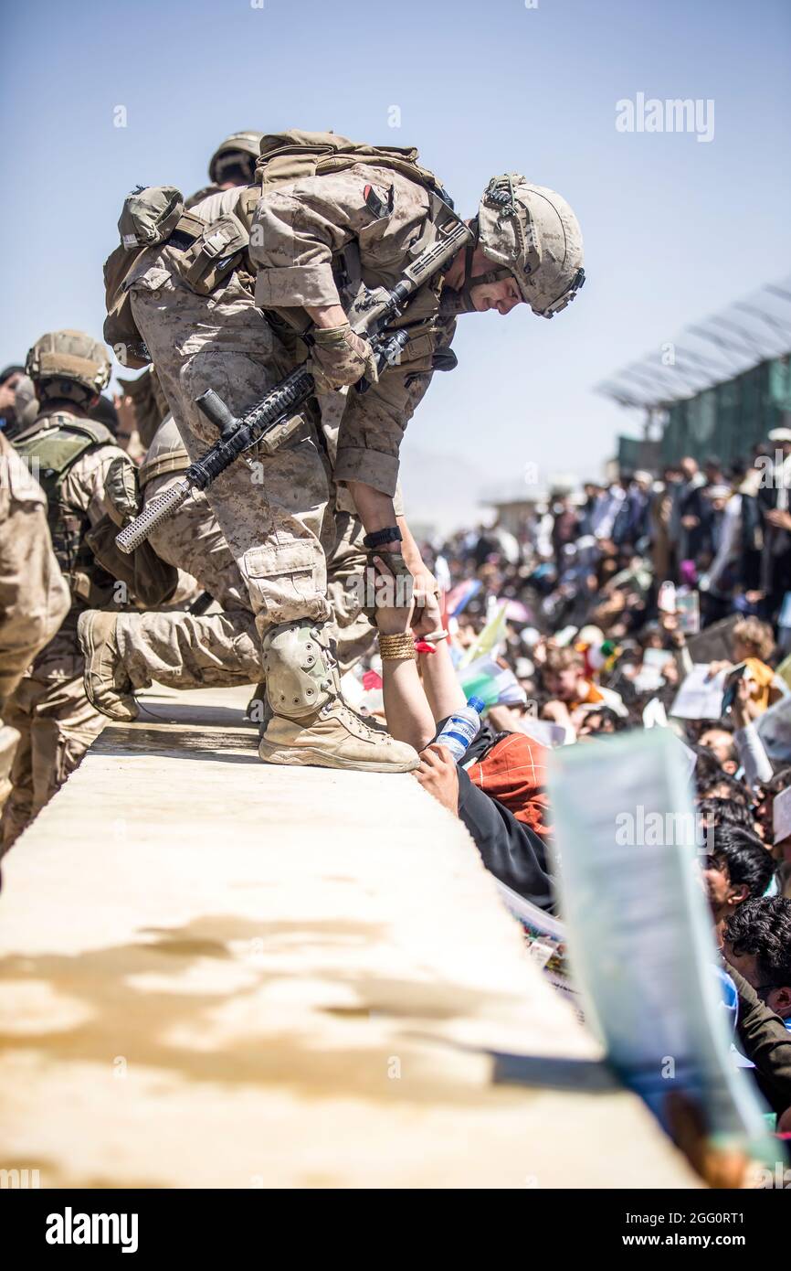 Ein Marine mit Special Purpose Marine Air-Ground Task Force-Crisis Response-Central Command (SPMAKTF-CR-CC) hebt während einer Evakuierung am Hamid Karzai International Airport, Kabul, Afghanistan, am 26. August eine Evakuierung auf. US-Dienstmitglieder unterstützen das Außenministerium bei einer geordneten Abseichung von designiertem Personal in Afghanistan. (USA Marine Corps Foto von Sgt. Samuel Ruiz). Stockfoto