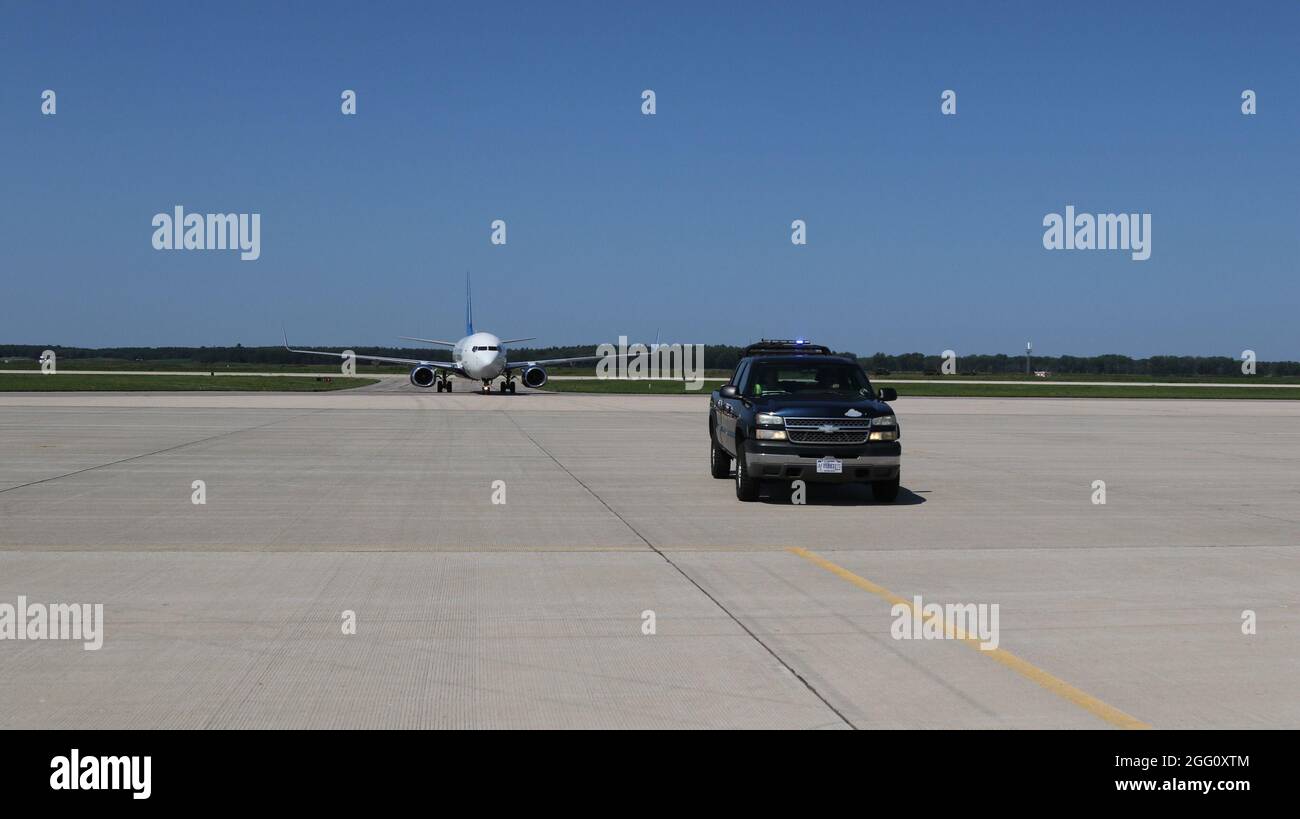 Eine Fluggesellschaft, die Afghanen befördert, wird von Bodenbesatzungen am Volk Field in Camp Douglas, Wisconsin, am 22. August 2021, geleitet. Das Verteidigungsministerium stellt über das US-Nordkommando und zur Unterstützung des Außenministeriums und des Heimatschutzministeriums so schnell wie möglich Transport, vorübergehende Unterbringung, medizinische Vorsorgeuntersuchungen und allgemeine Unterstützung für bis zu 50,000 afghanische Evakuierte in geeigneten Einrichtungen, in permanenten oder temporären Strukturen bereit. Diese Initiative bietet gefährdeten Afghanen an sicheren Orten außerhalb Afghanistans wesentliche Unterstützung. (USA Armeefoto von Sgt. Bill Washburn/TF M Stockfoto